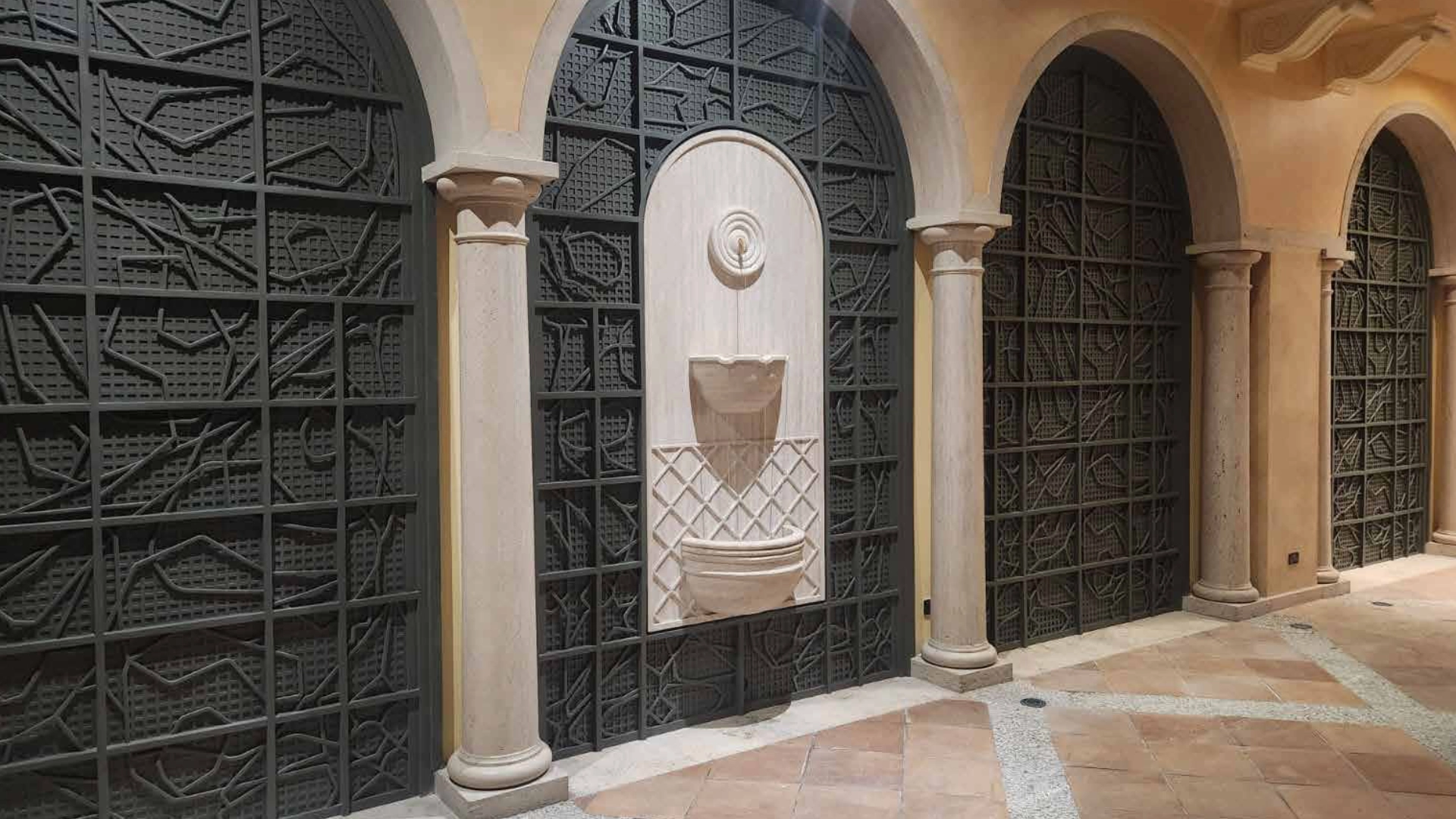 Arch-shaped 3D printed wall cladding panels with tropical mural artwork set into arched niches