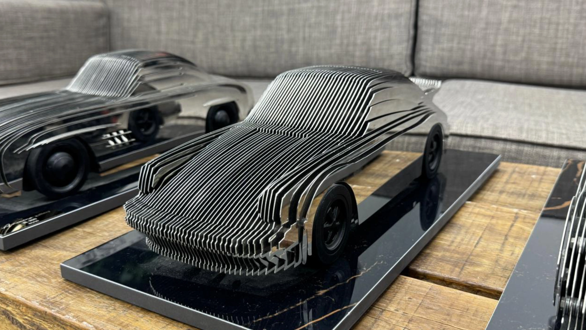Polished metal car sculpture displayed in the workshop.