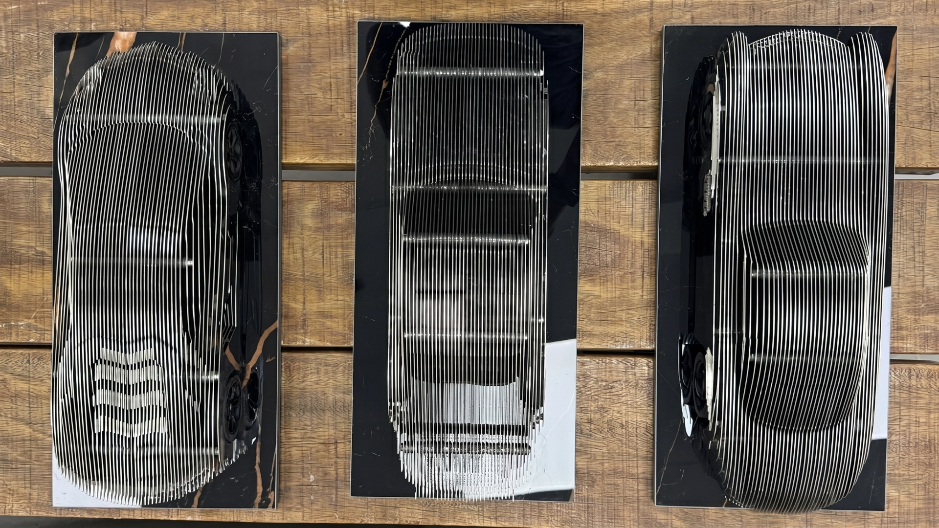 Metal-finish car sculpture displayed with a reflective surface