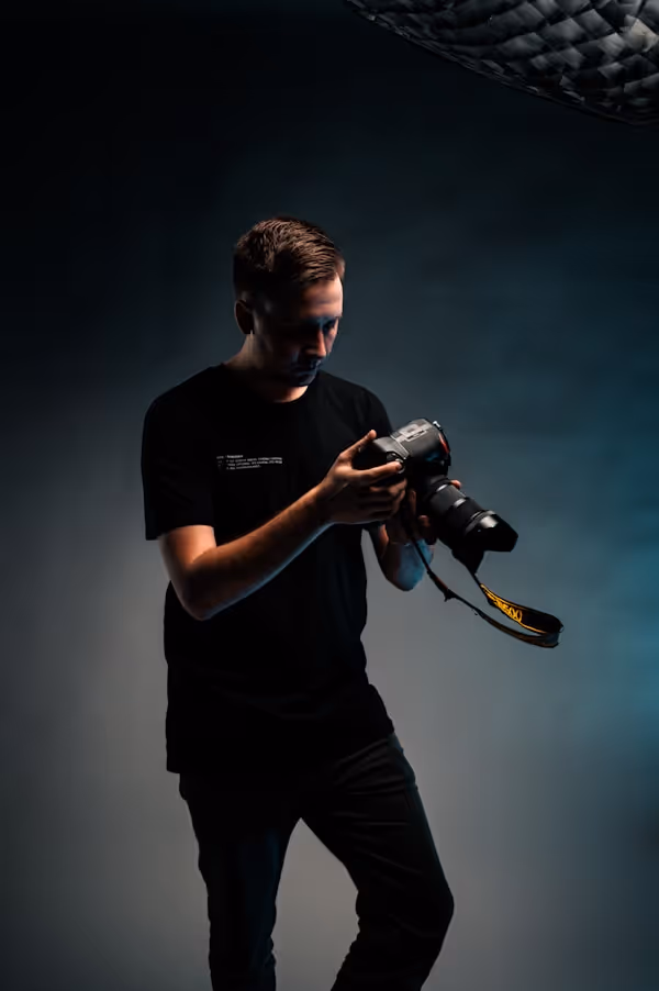 man in black crew neck t-shirt holding black dslr camera