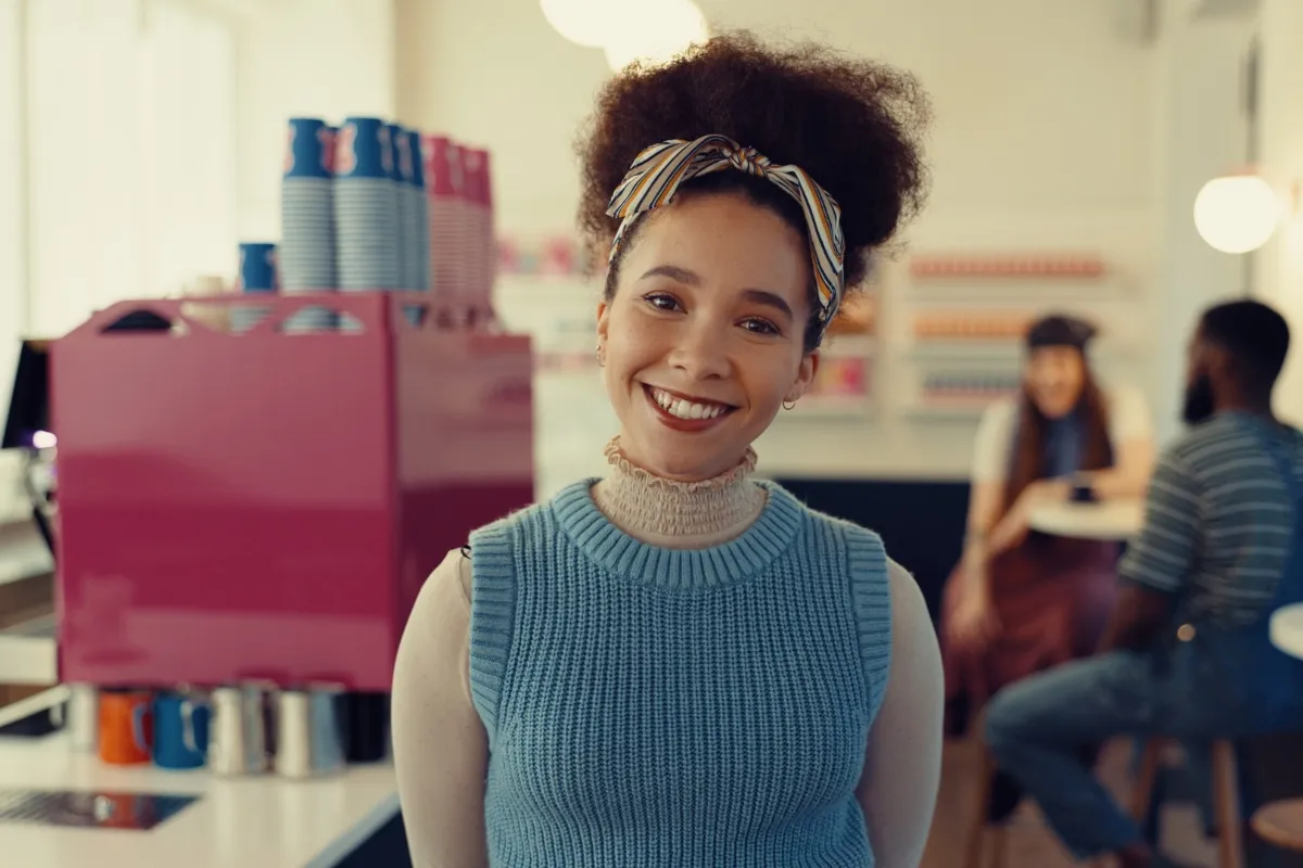 Smiling woman in blue sweater and headband standing in colorful office