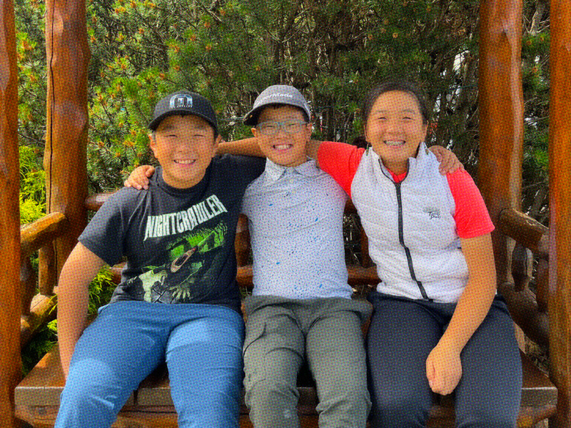 Three students hugging and smilling