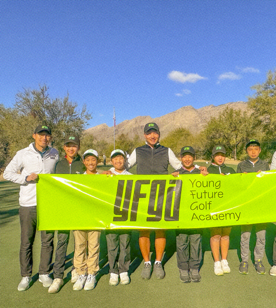 6 students and 3 instructors stand in  a row holding a green yfga banner at a sunny golf course with an American flag