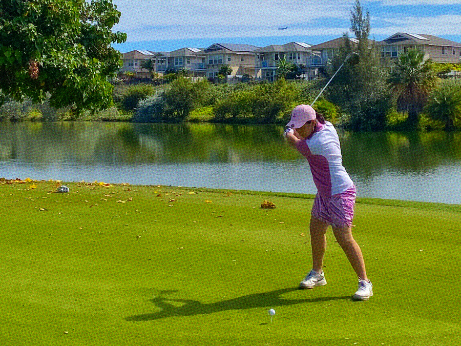 Girl swinging golf club at golf course