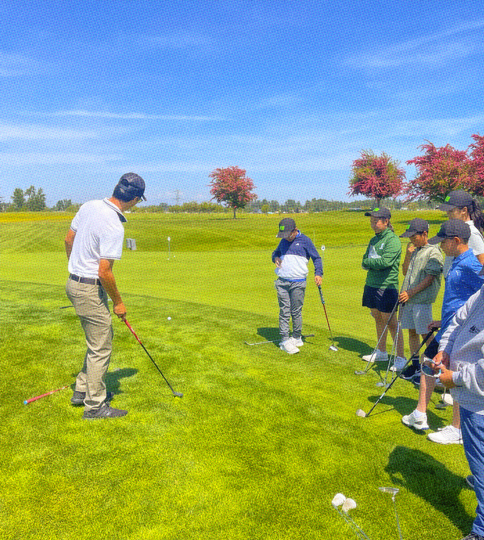 golf instructor teaching a group of students at a golf course