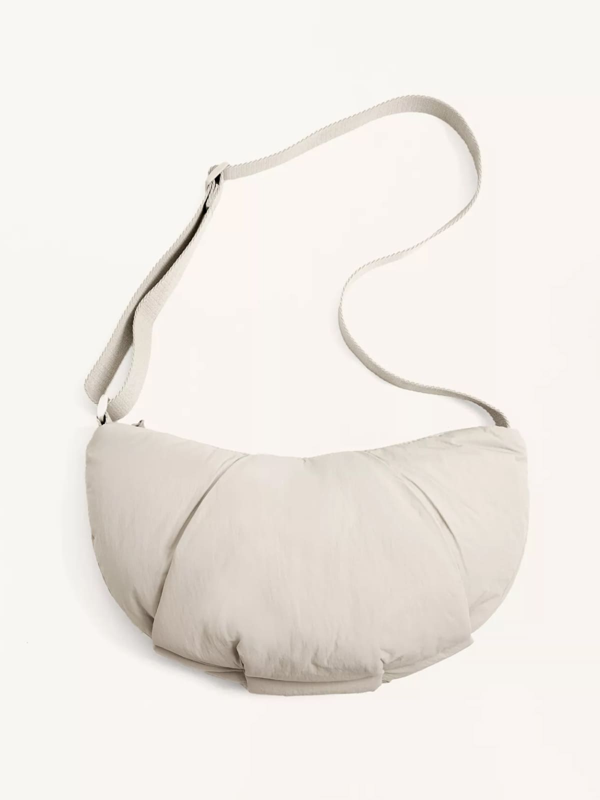 Soft white puffy crescent-shaped shoulder bag with long strap
