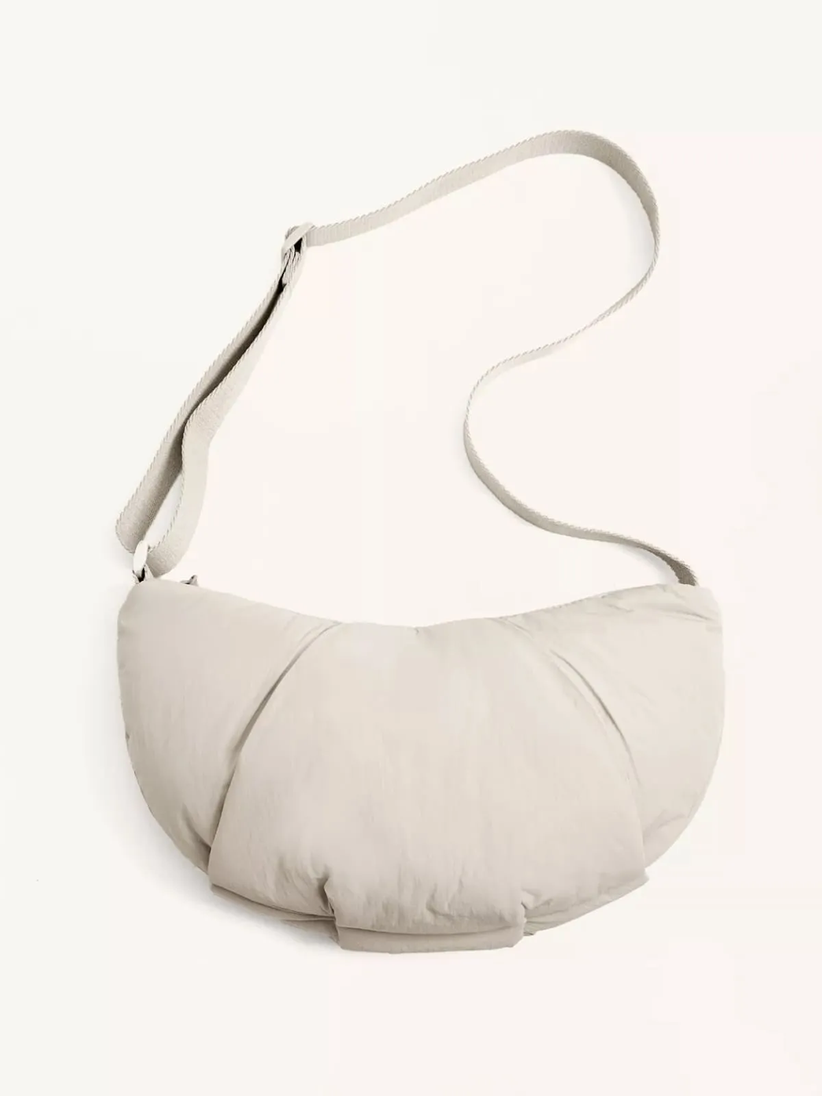 Soft white puffy crescent-shaped shoulder bag with long strap