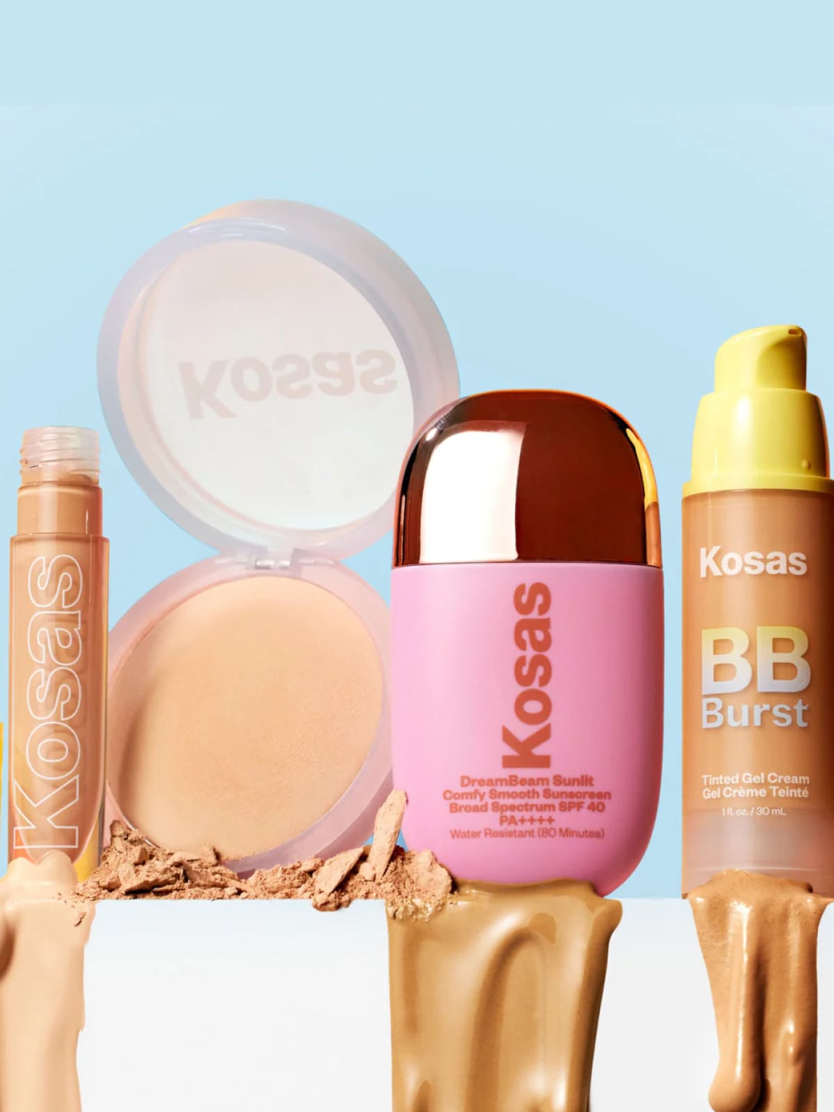 Kosas makeup products including liquid concealer, powder compact, sunscreen, and BB cream displayed against light blue background.