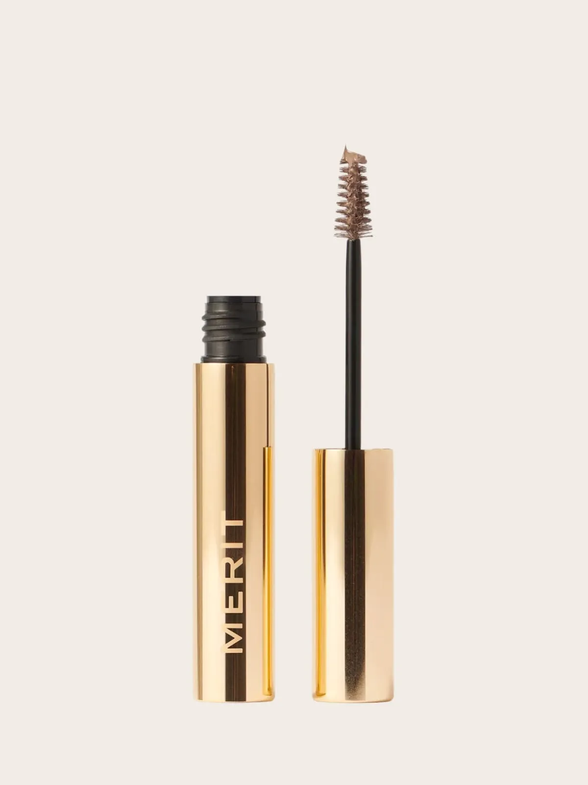 Open mascara tube with brush applicator showing brown formula on neutral background