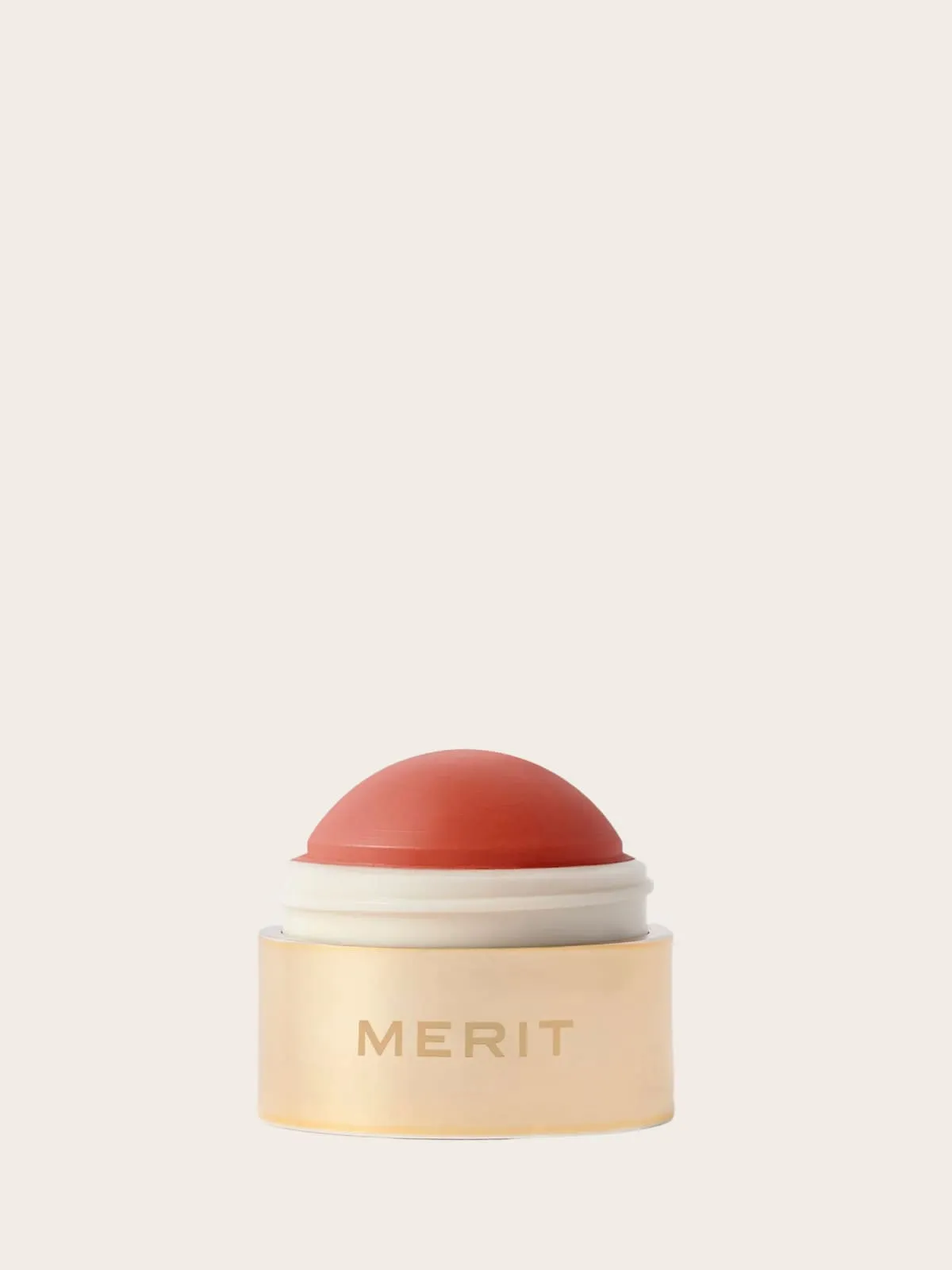 Merit skincare jar with red dome lid and cream-colored container on beige background