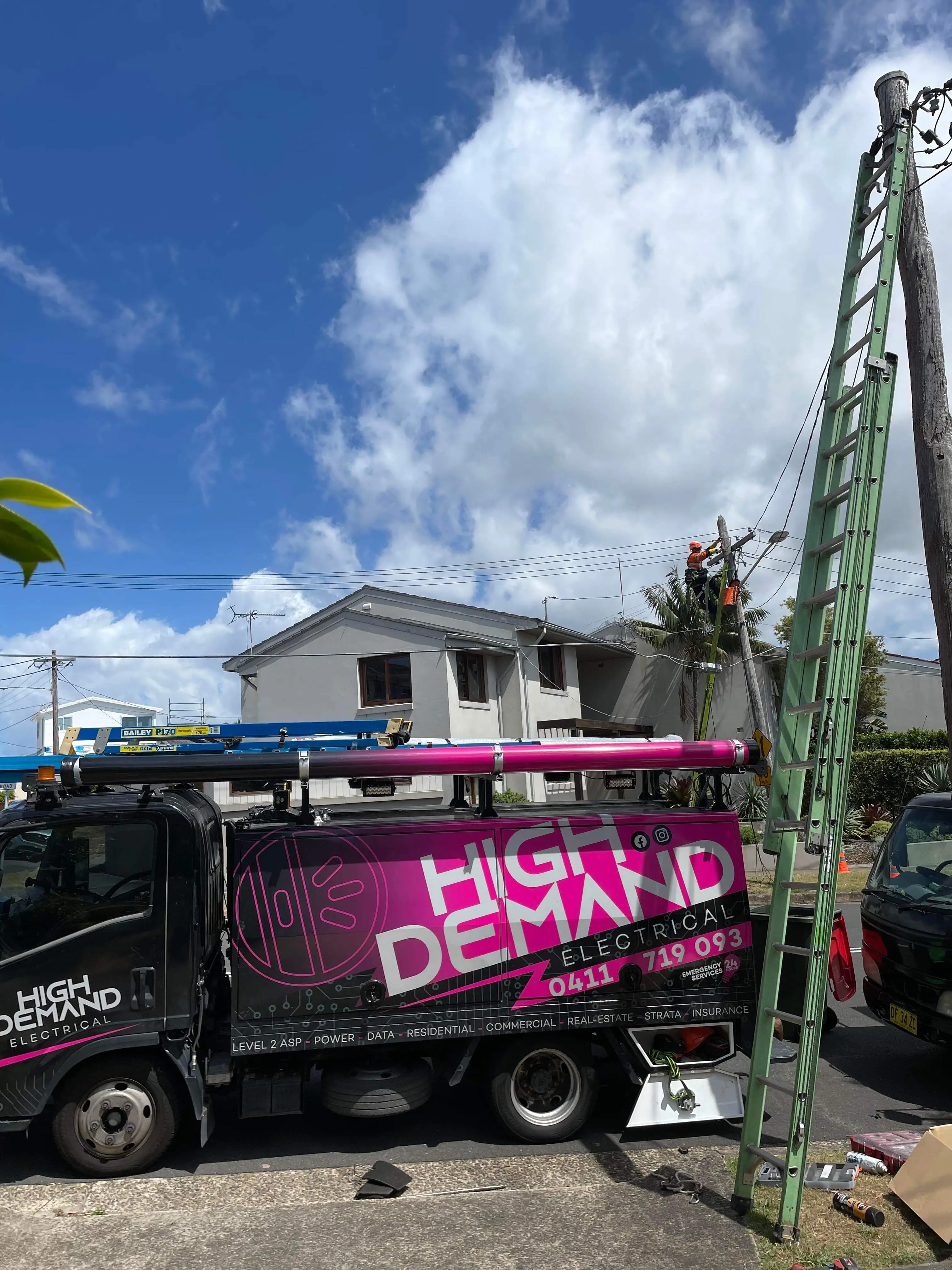 Licensed electrician installing tiger tail safety covers on overhead power lines in Sydney