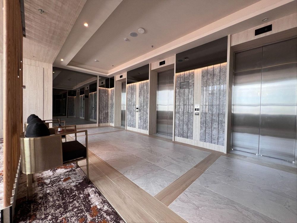 Guest-floor lift lobby with stone-clad doors