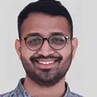 A man with glasses smiling for a picture.