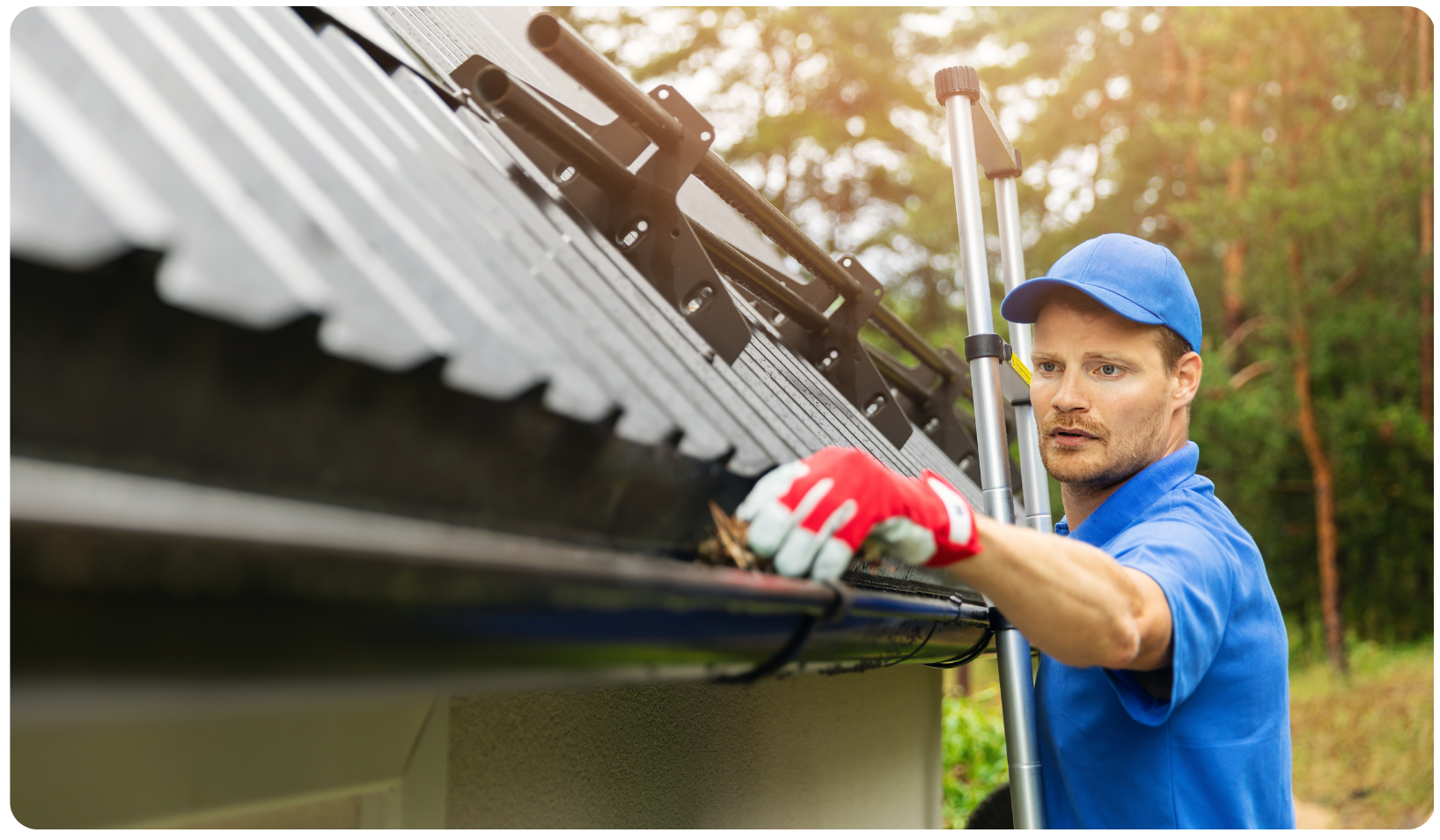 white guy in blue shirt and hat cleaning out a gutter