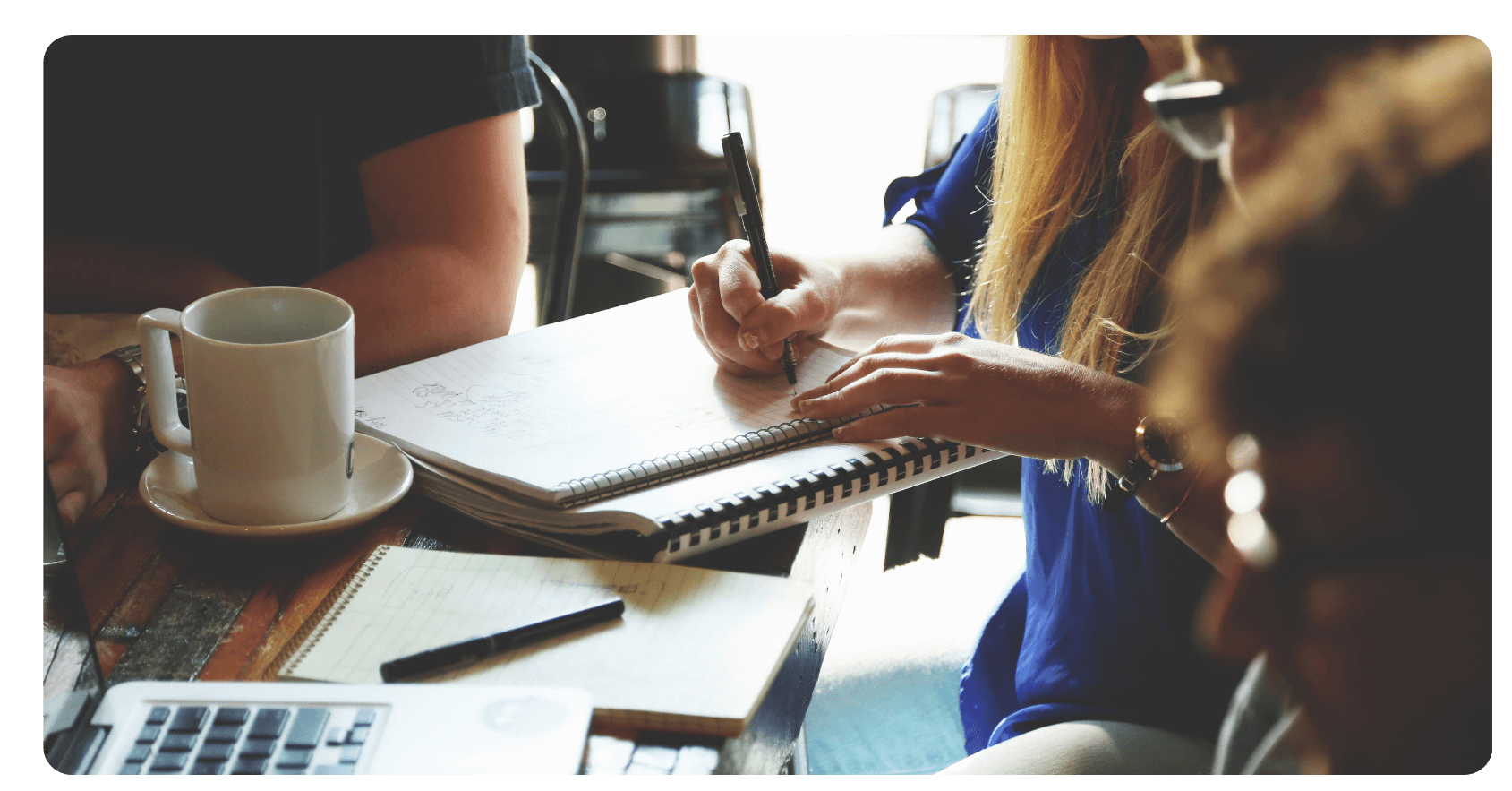 three people around table in a meeting