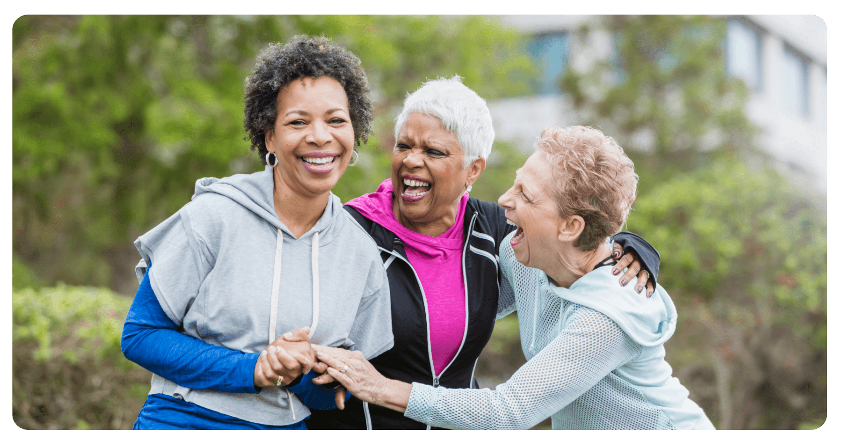 three older mixed women laughing together