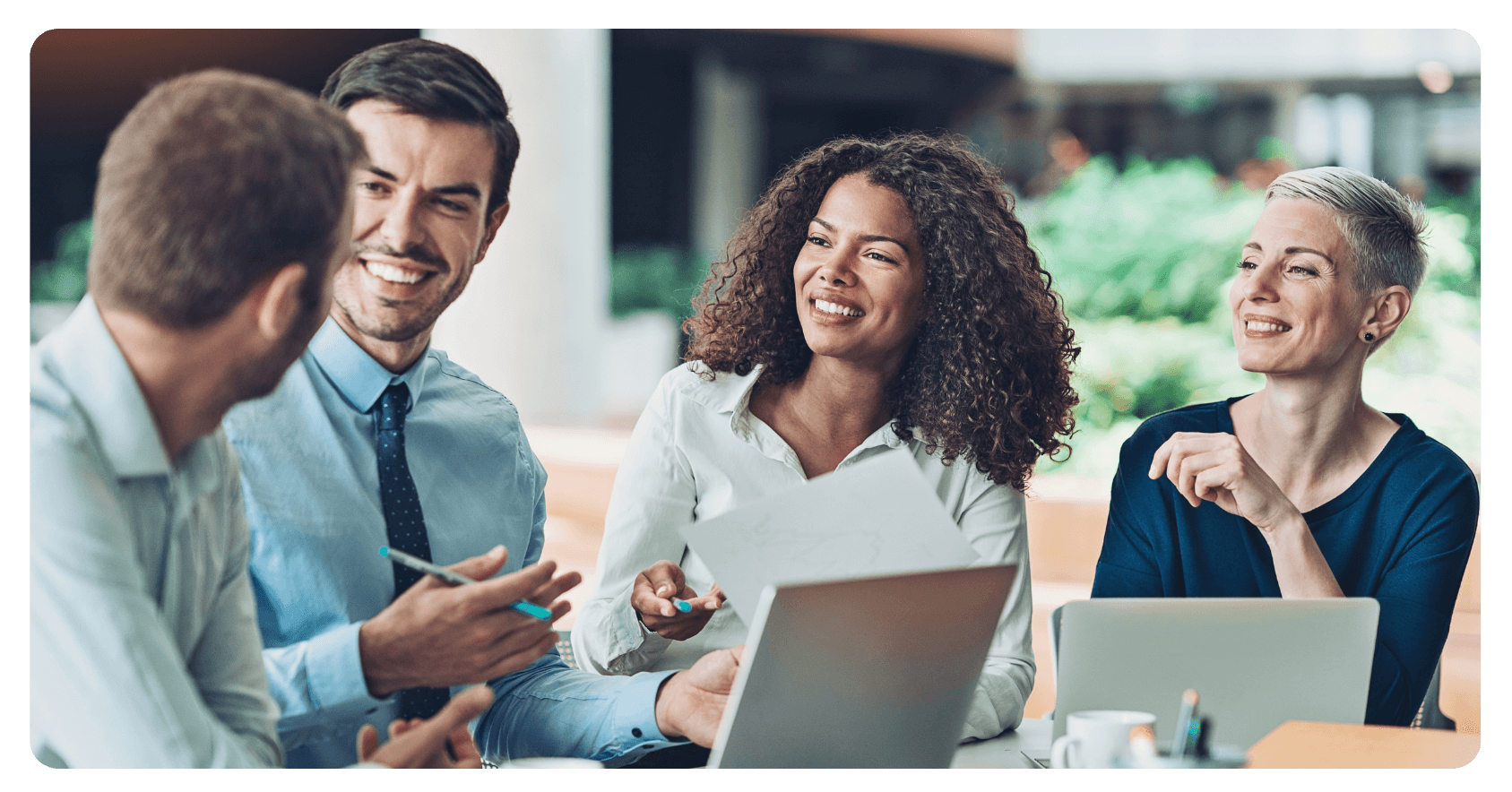four people in a business meeting with laptops