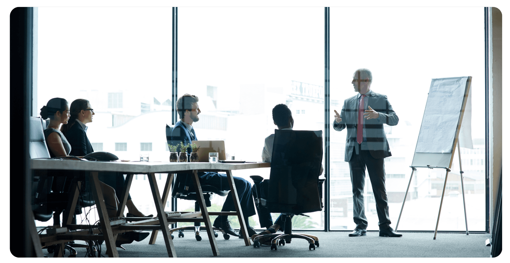 group of four people in an office learning from one teacher