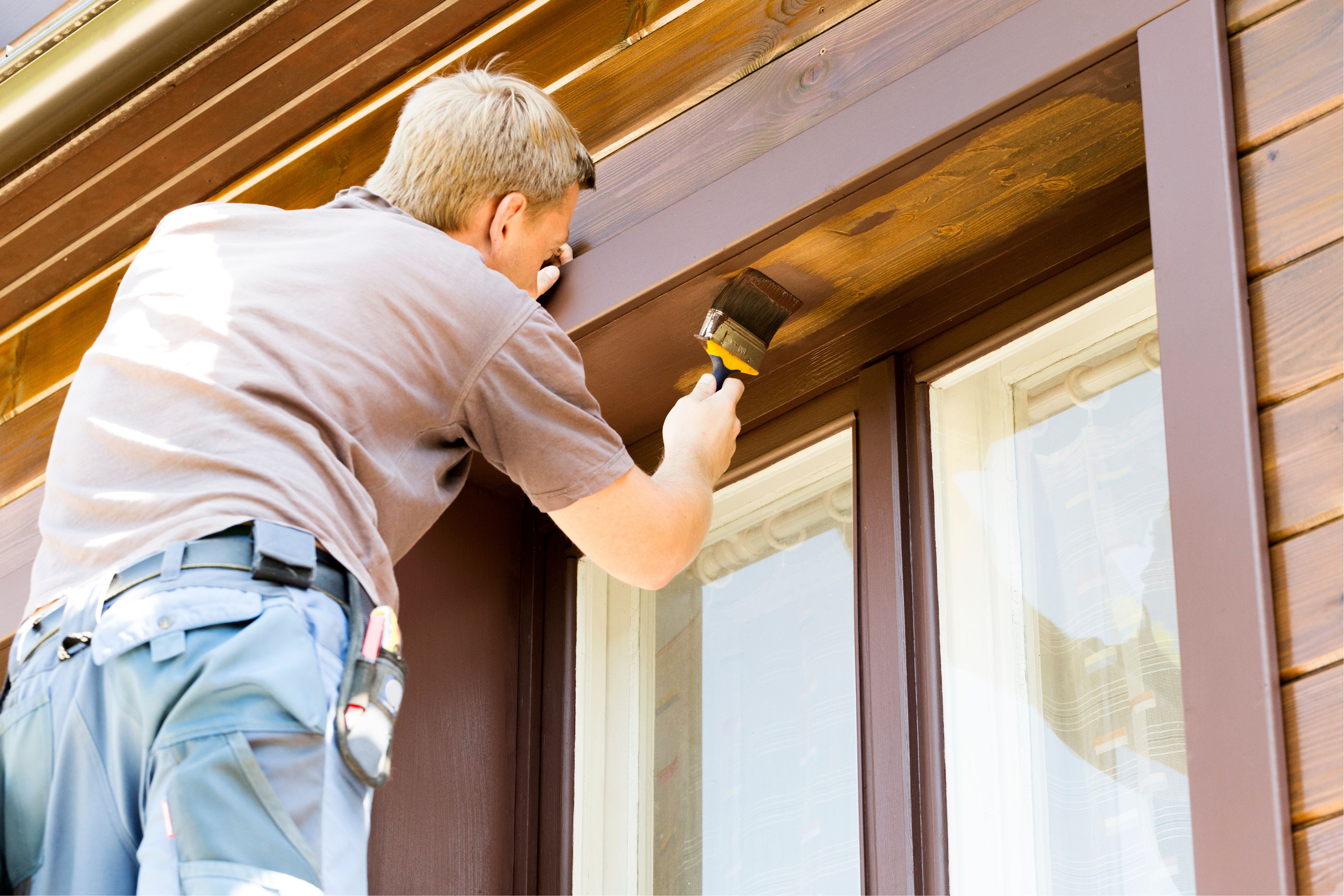 A man makes sure he's keeping up with his home maintenance by doing some painting.