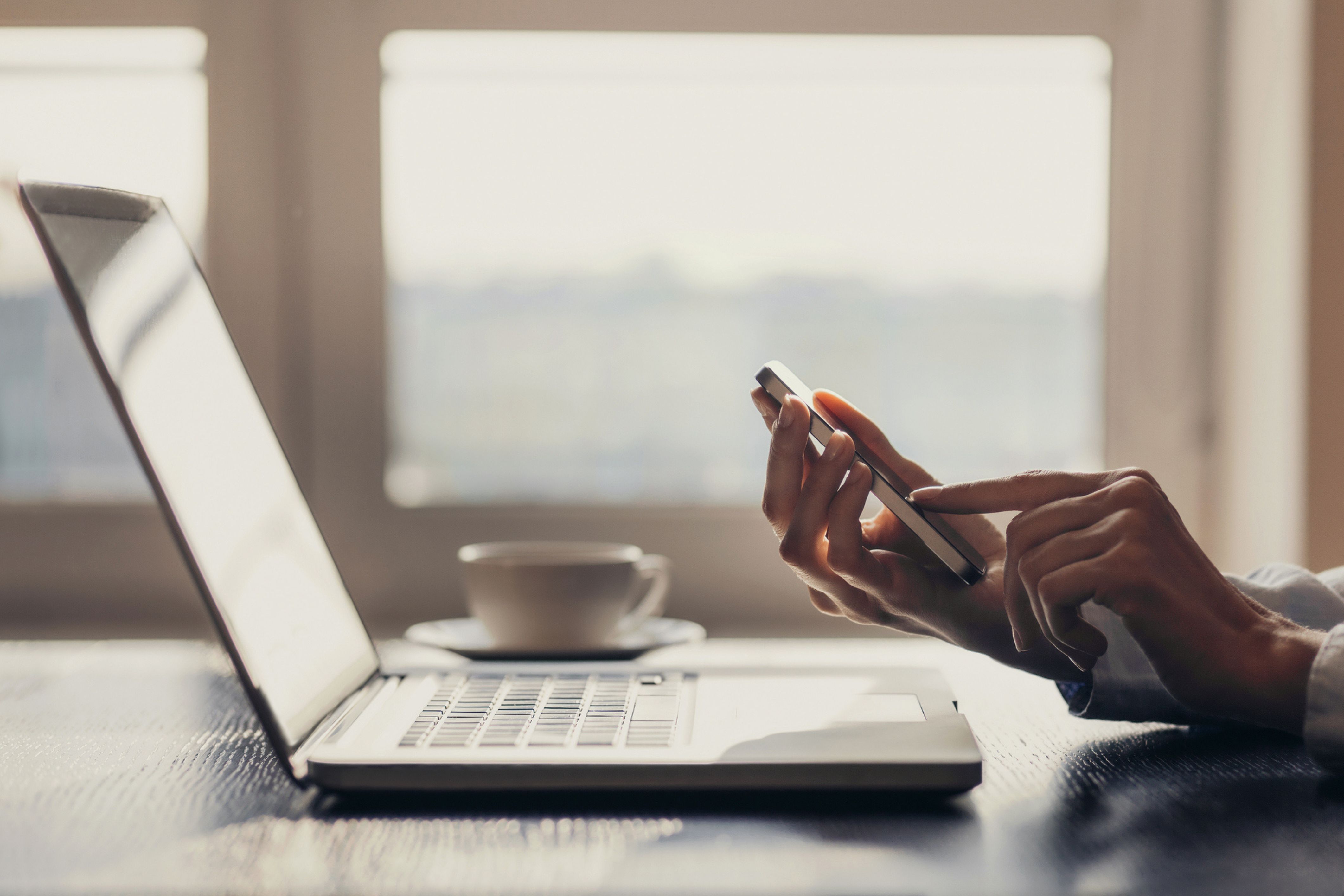 A person uses their phone and tablet to prevent social engineering attacks.