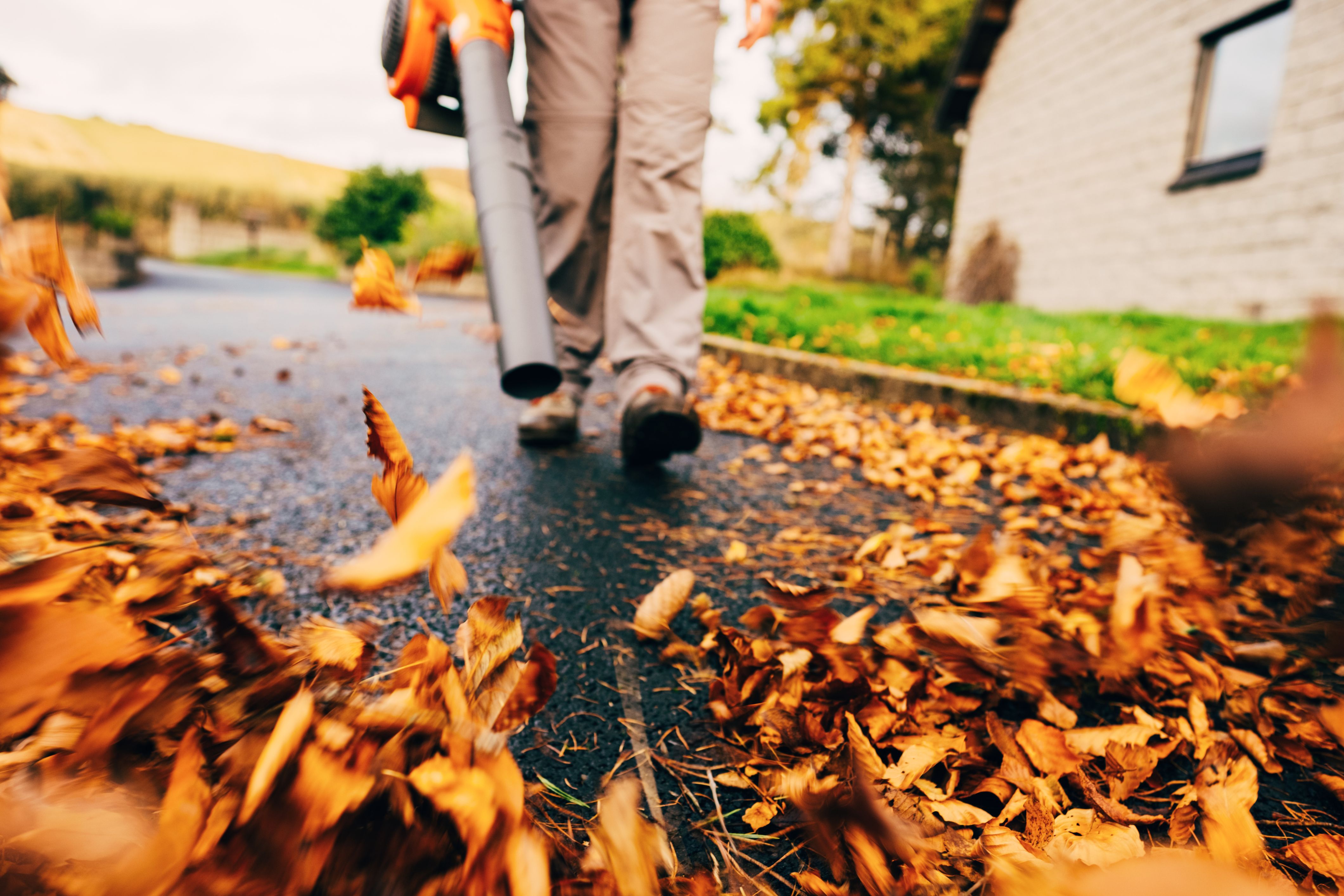 Tasks like blowing leaves off your driveway are necessary for fall maintenance.