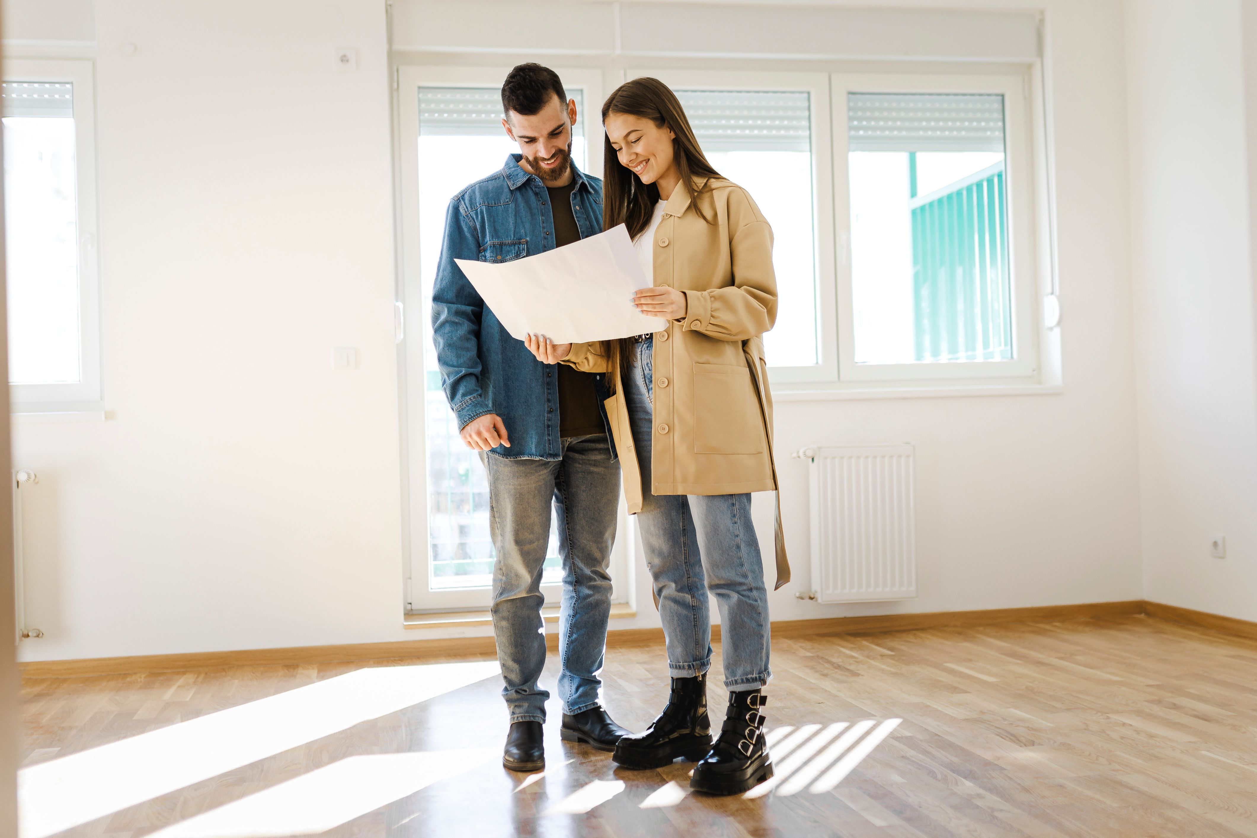 A couple stands in their new home planning how they will settle in.