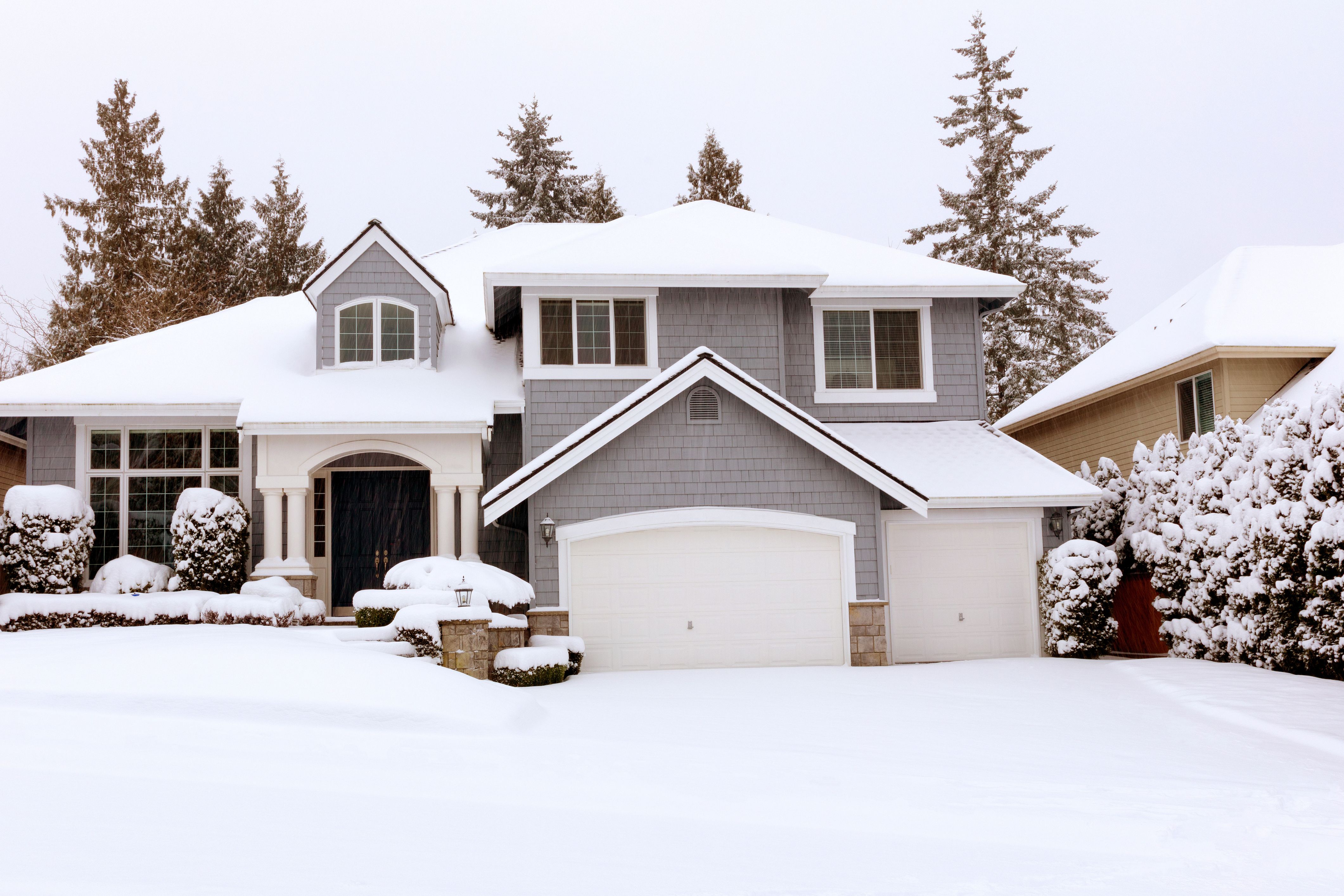 A snowy house serves as a reminder of winter maintenance tasks you might be forgetting in your HOA community.