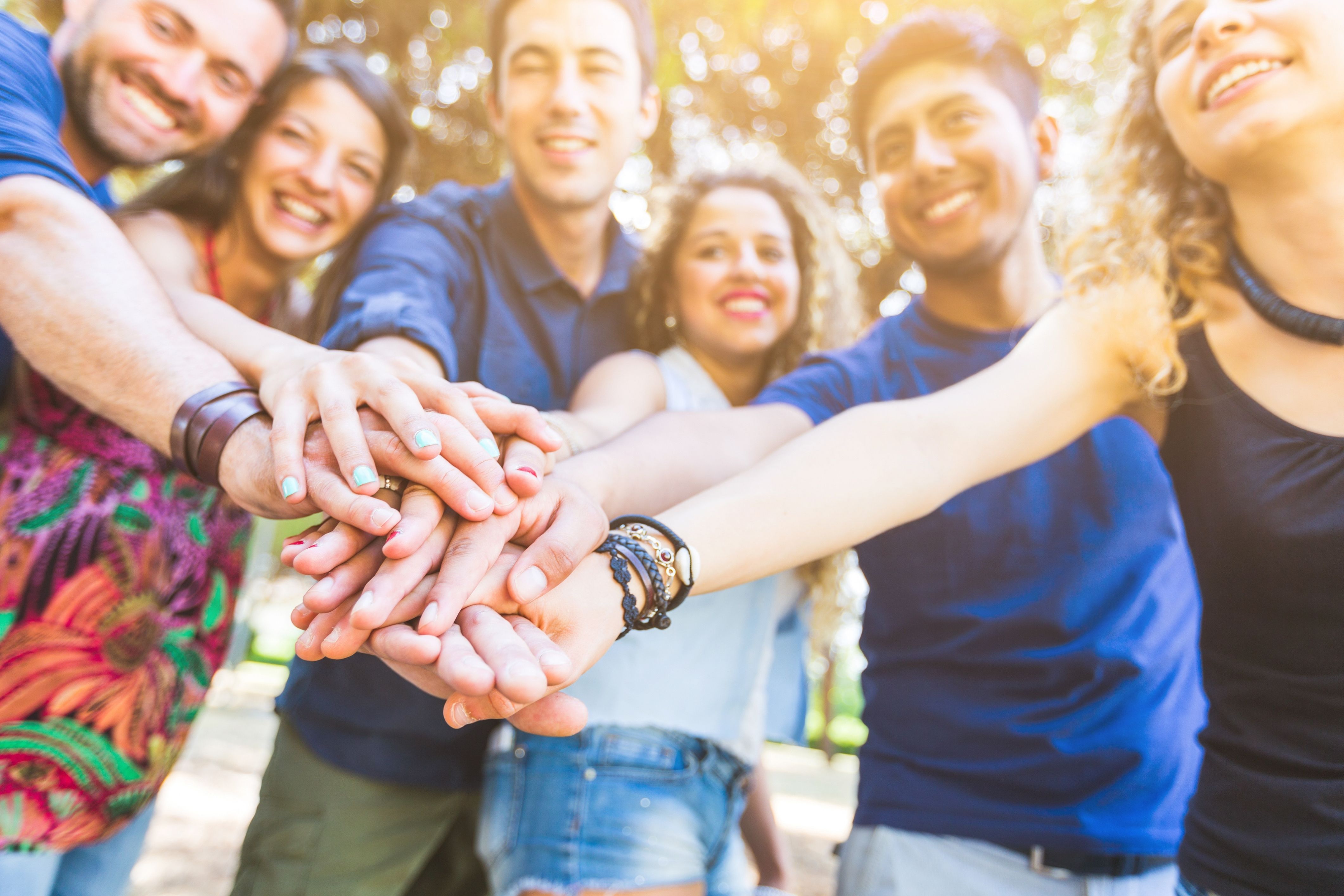 A group of people puts their hands together as a sign of goodwill amongst neighbors.