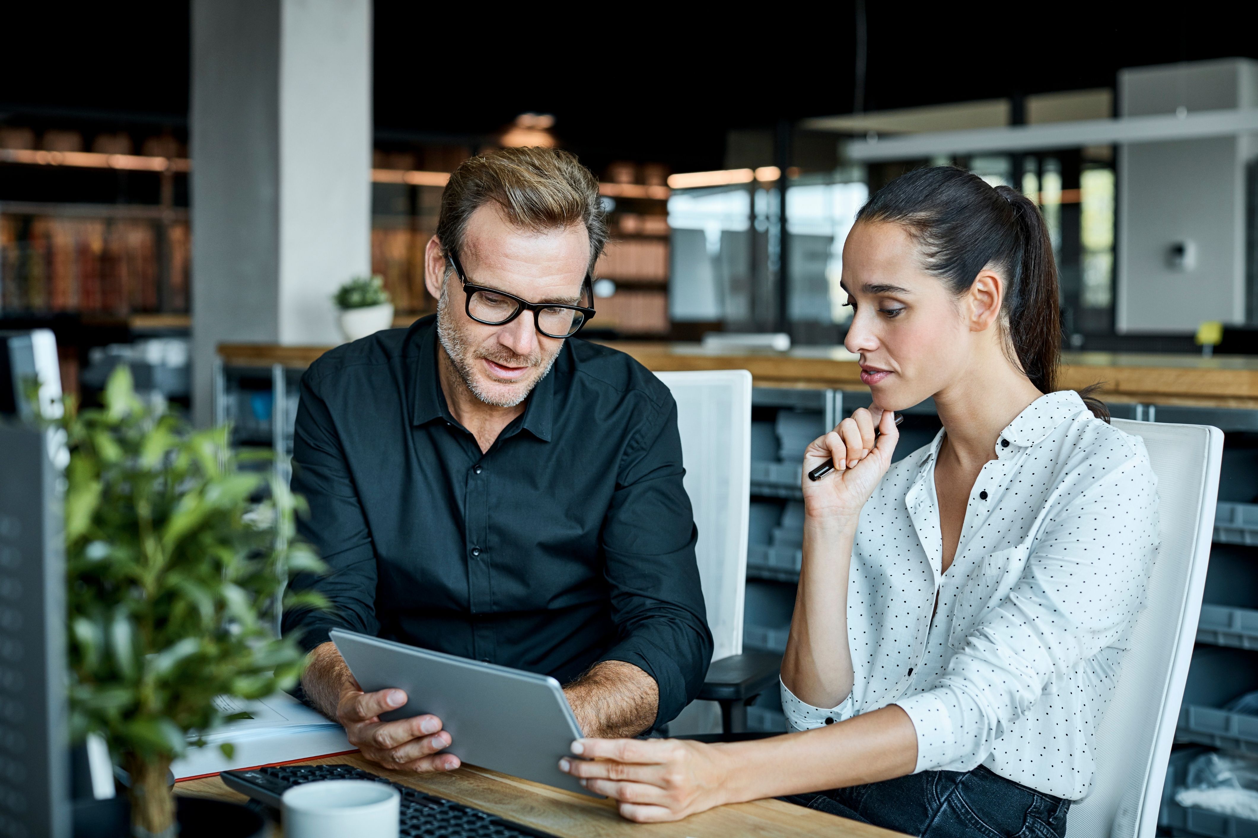 A man and a woman sit going over TownSq's new feature updates.
