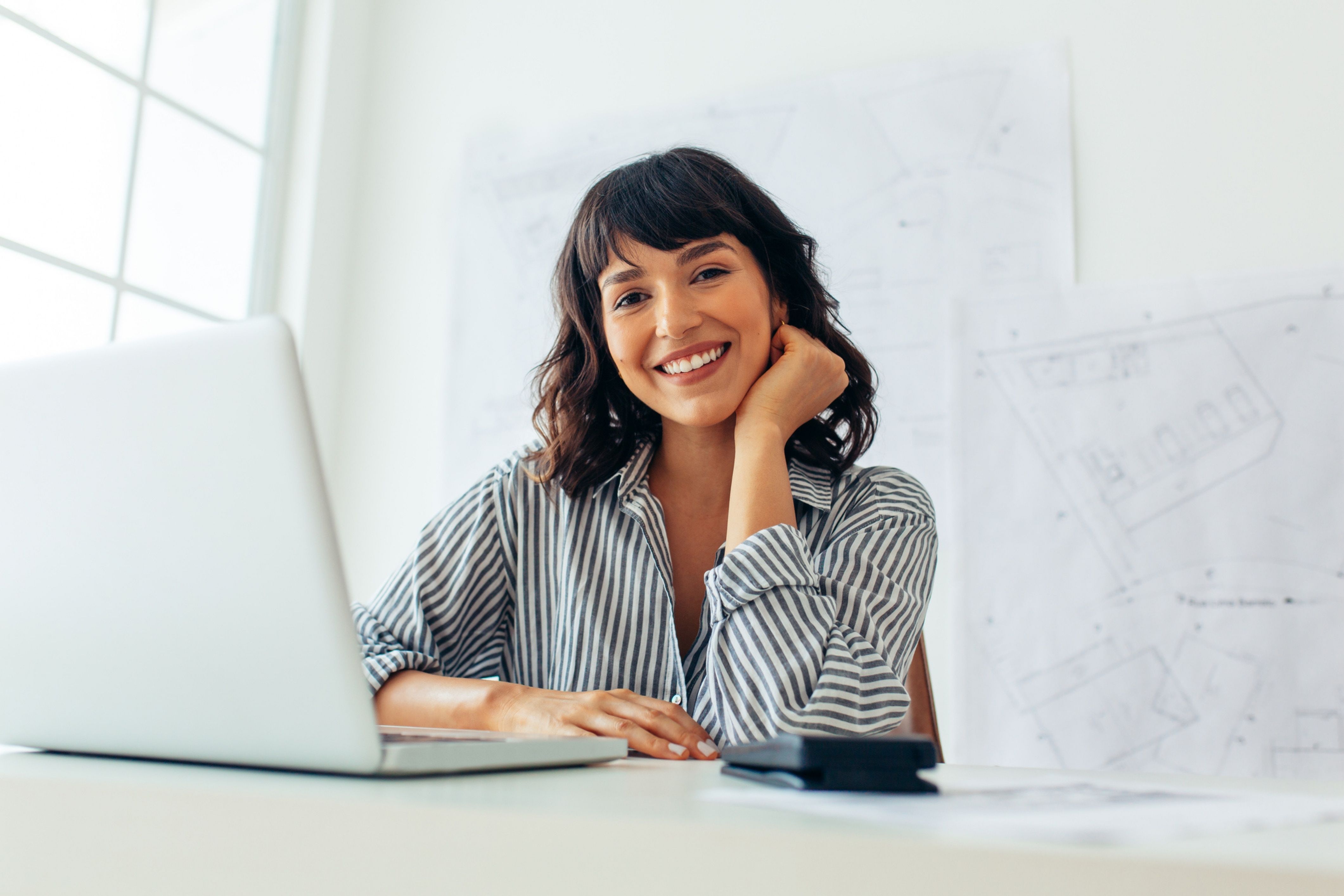 A property manager sits at her desk, working through tasks for managing her HOA community.