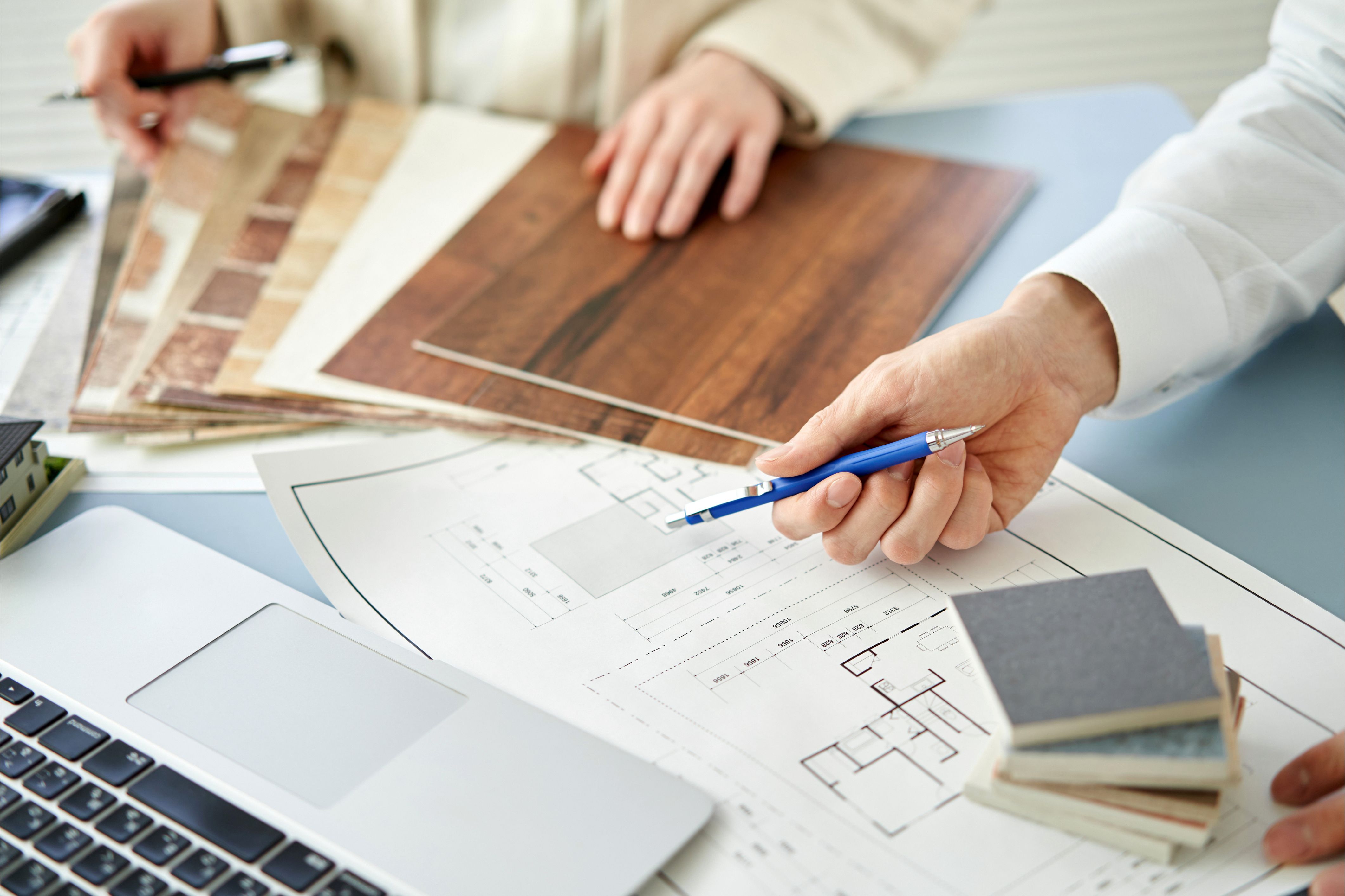 The hands of two property managers can be seen working at a desk.