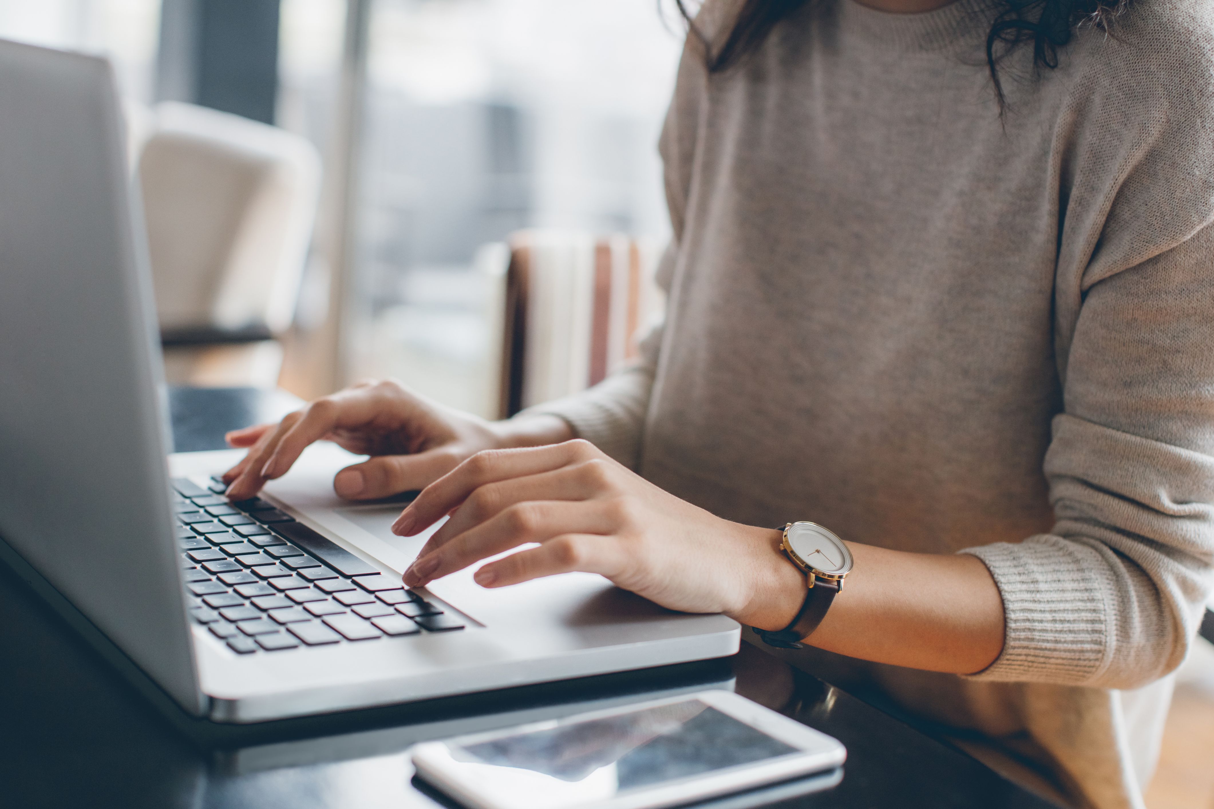 A woman sits at her computer checking out her HOA's community website.