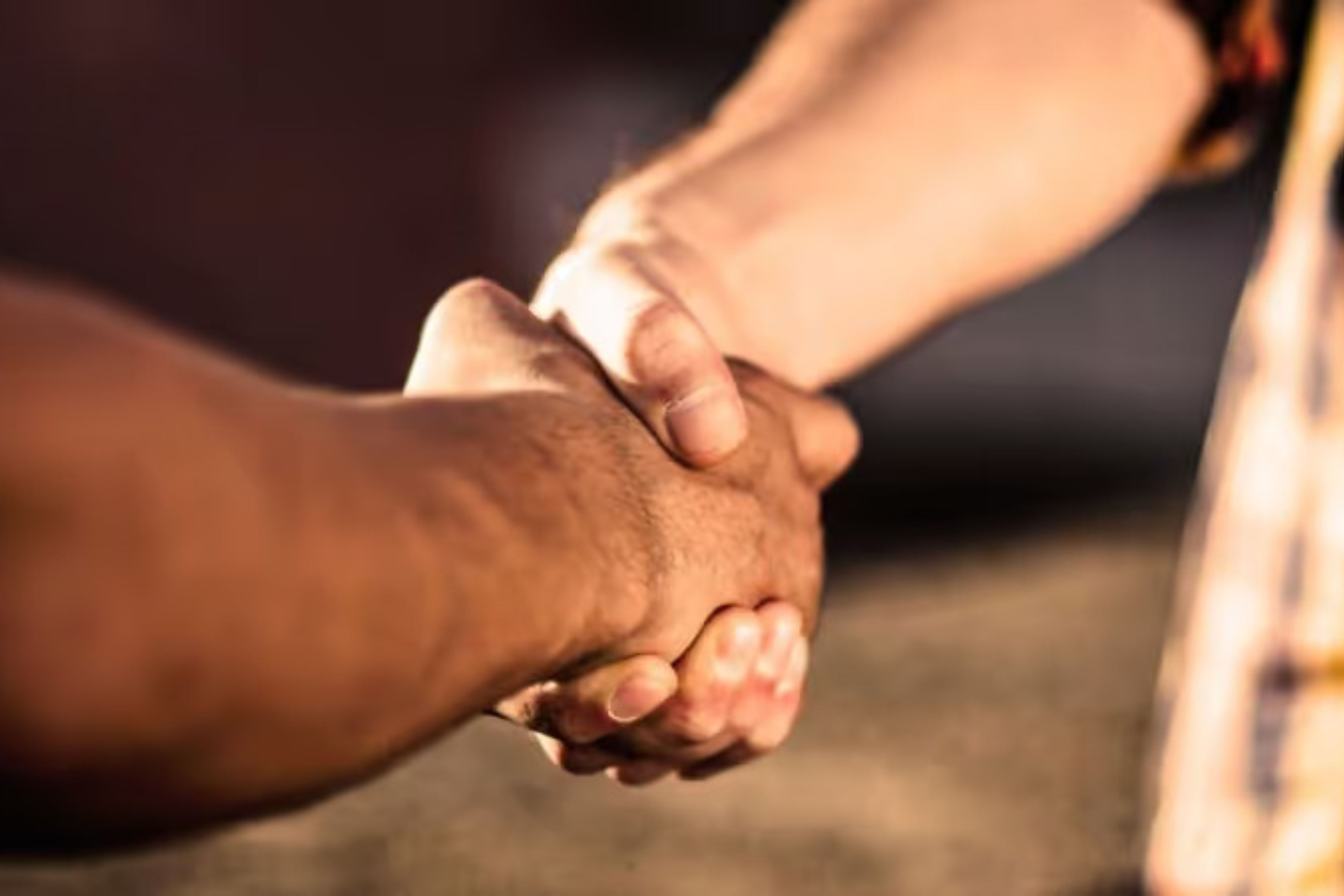 An HOA board member shakes hands with a vendor, maintaining a cordial relationship.