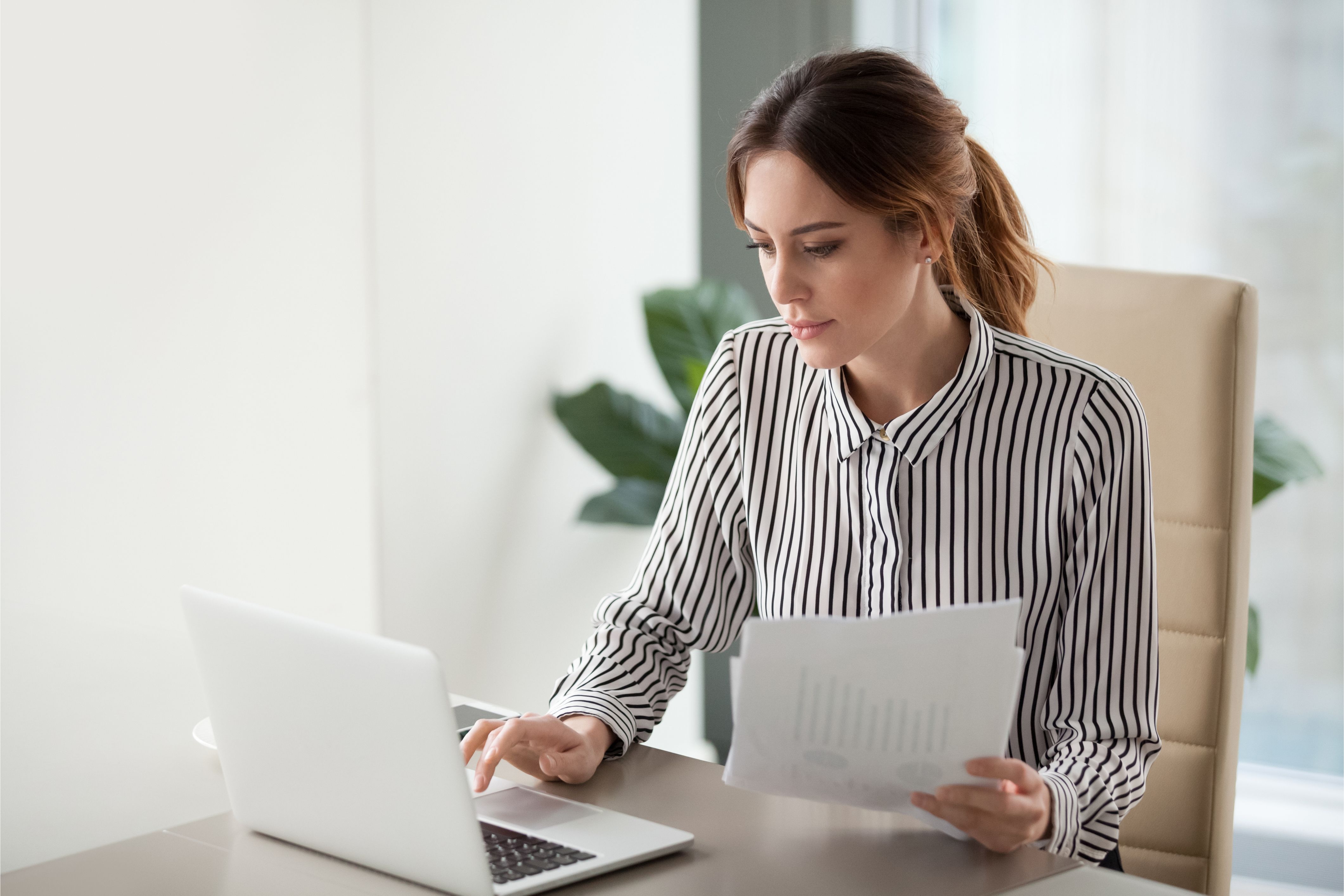 An HOA community manager sits at her laptop writing an HOA violation letter.