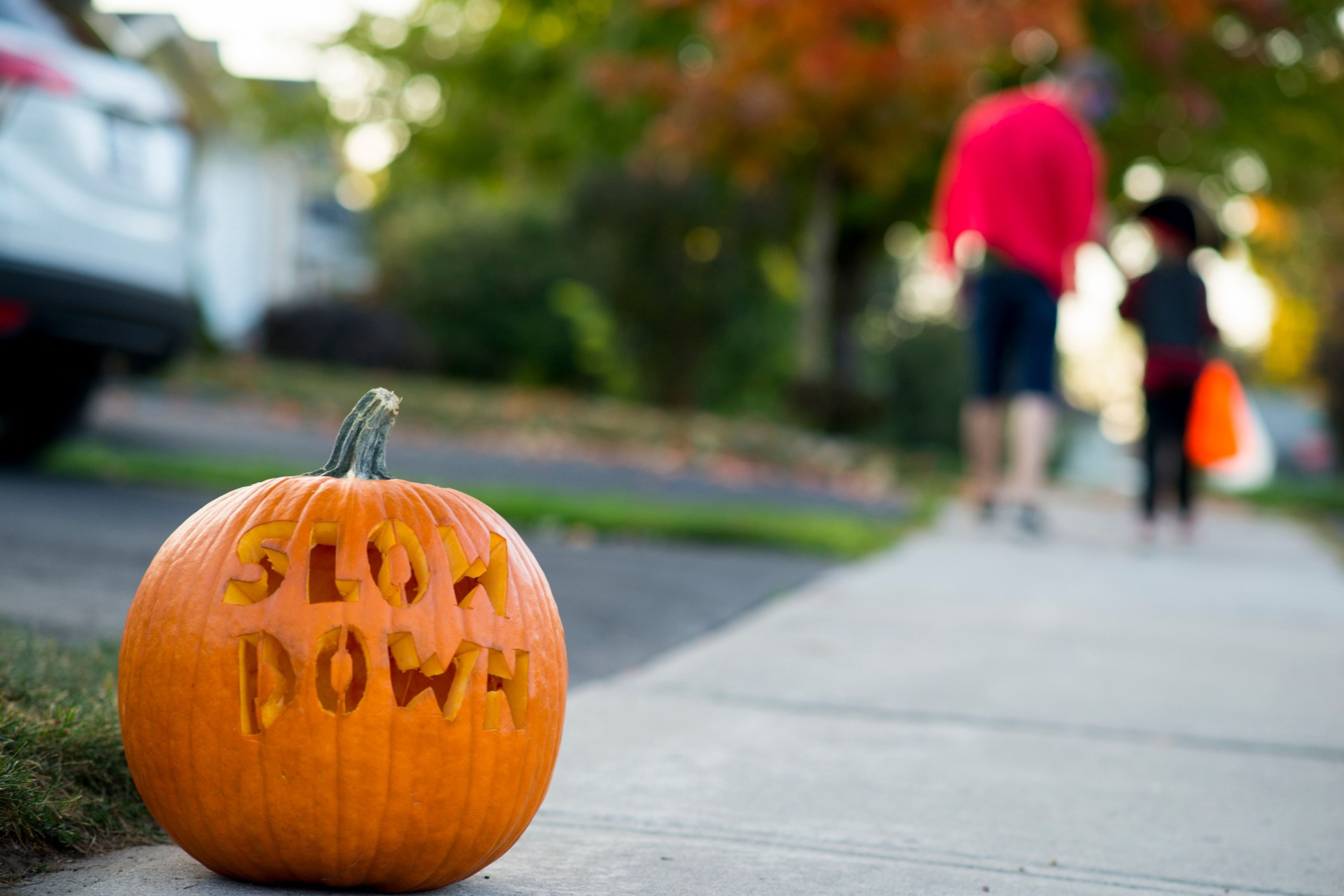 An HOA community puts out a pumpkin carved with the words "Slow Down" in order to encourage safe driving.