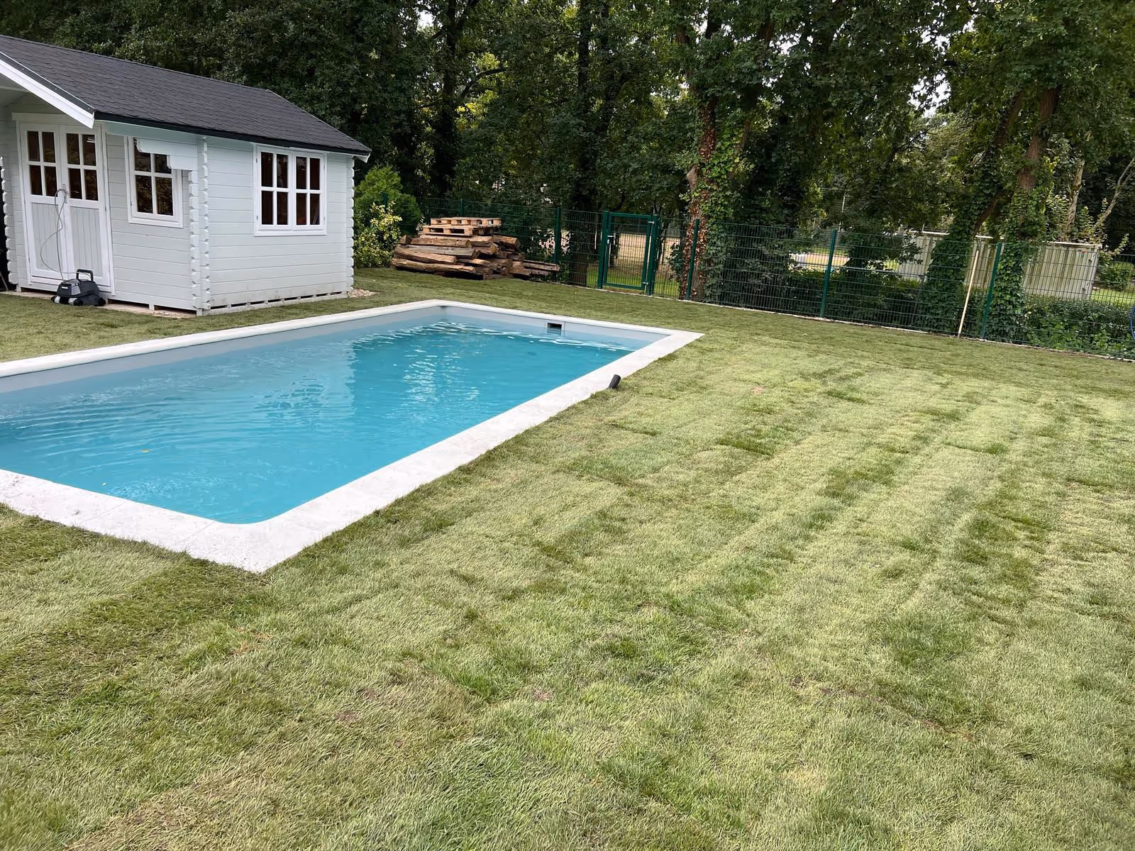 Erfolgreiche Rasenarbeiten neben einem Pool