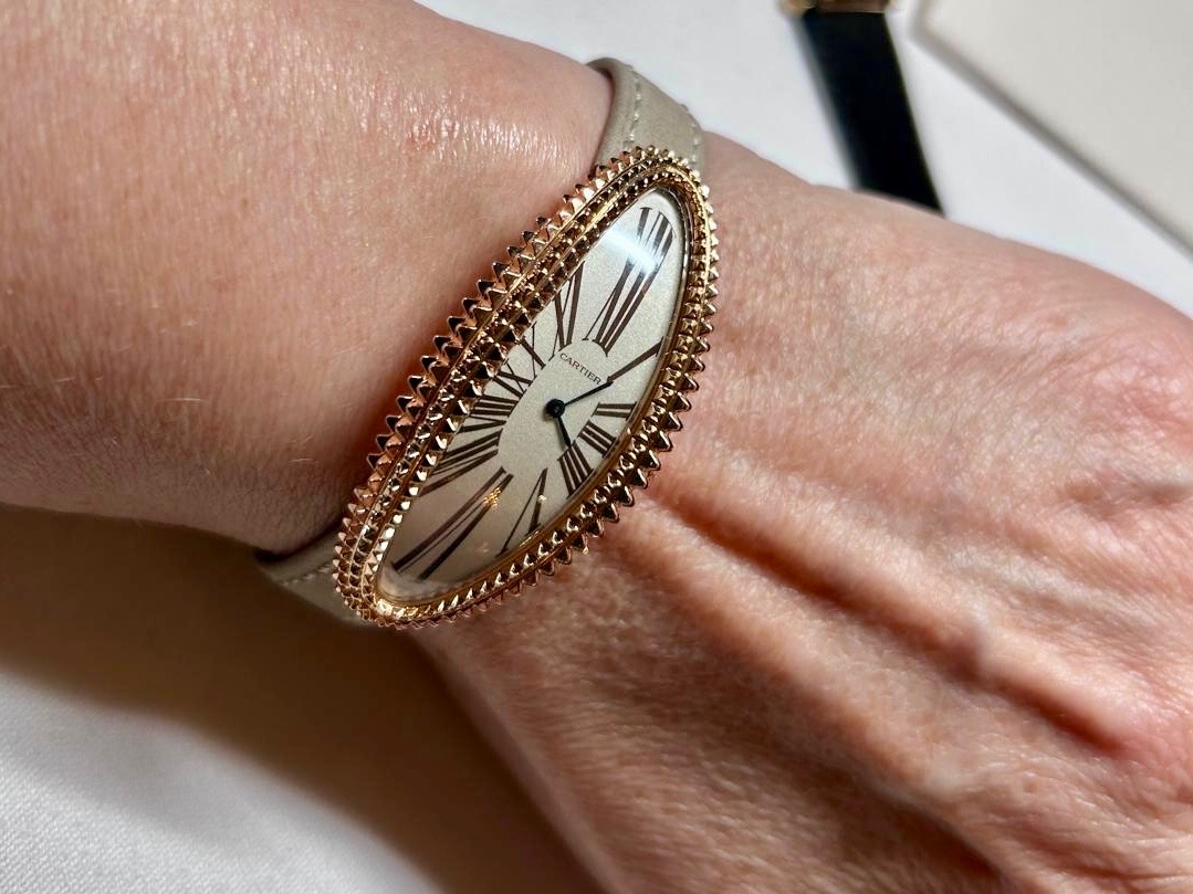 A woman's wrist wearing a Cartier 'Baignore Allongée' watch