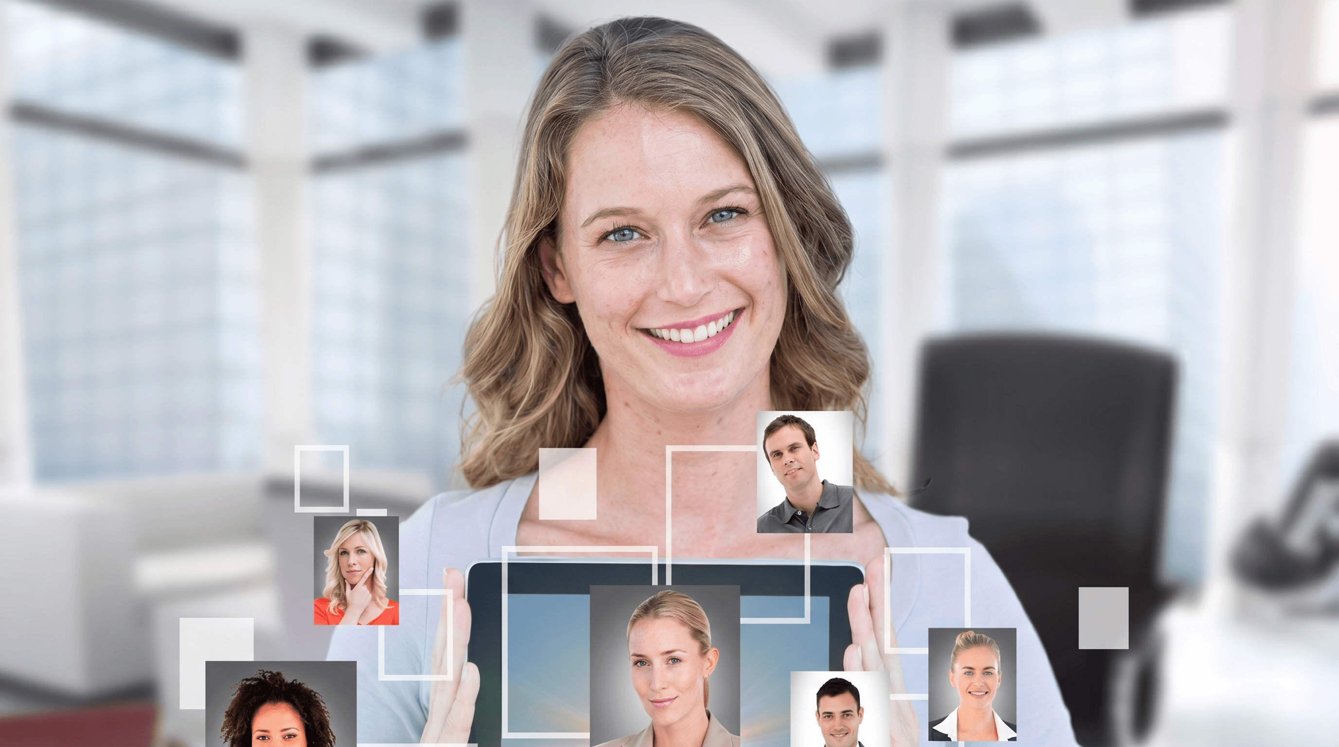 A woman holding a tablet displaying a grid of various profile pictures of people. She is smiling and appears to be in an office setting.