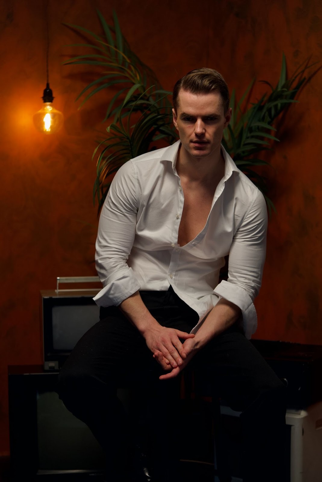 Chyrpe man in a tight white shirt looking into the camera