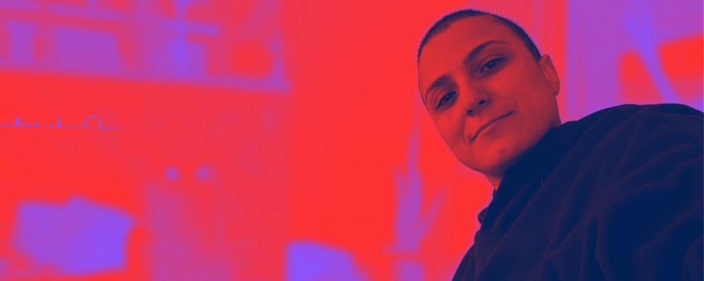 A portrait of me looking at the camera and smiling, the background is blurred. The picture has a red filter for the highlights and a purple one for the shadows