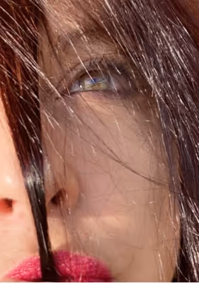 Selfie of Rooarty half face showing on the picture, her green/orange eye looking up. She's wearing pink lipstick, and her auburn long straight hair is over her nose and around her eye.