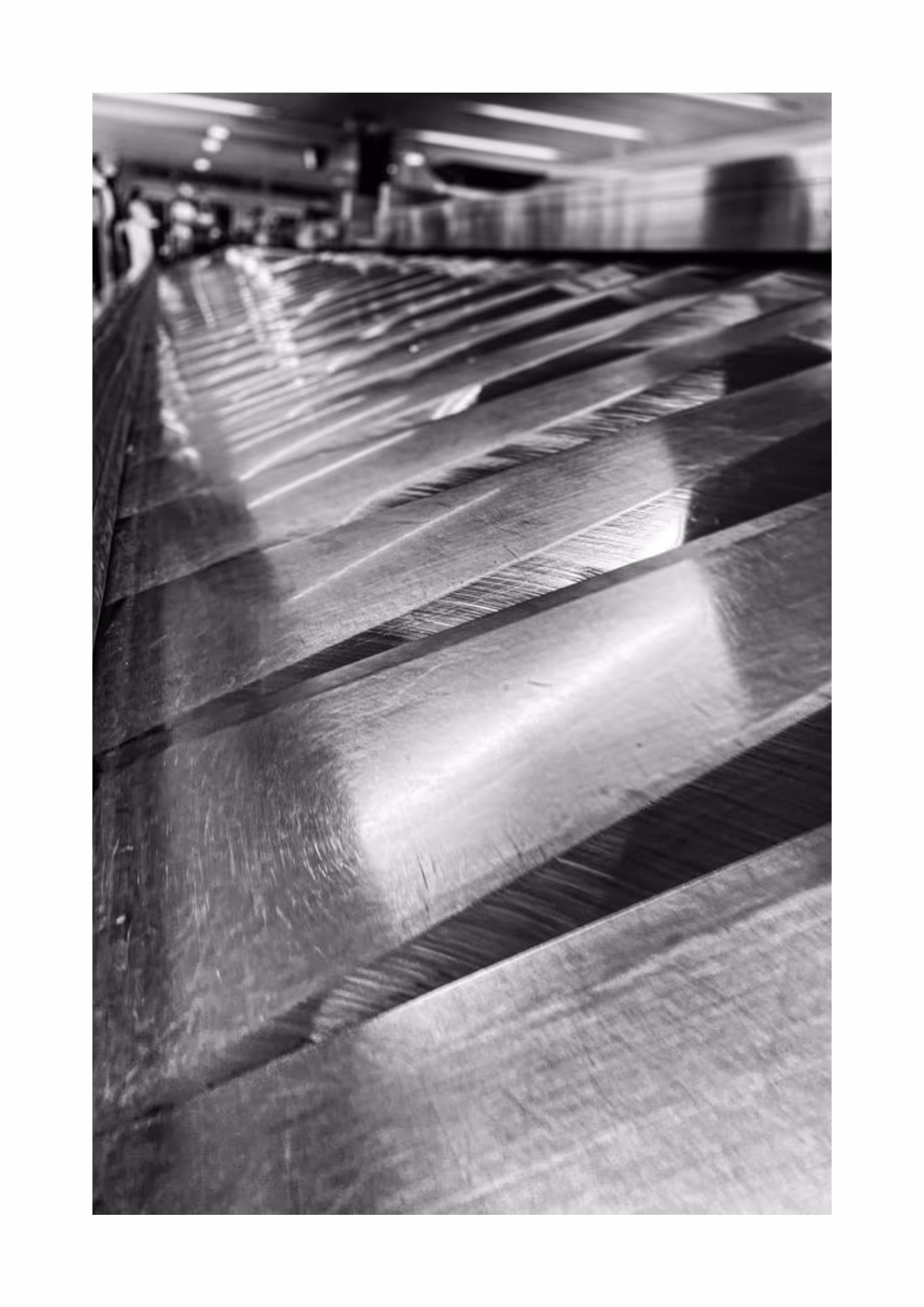 Black and white photo of a baggage carousel at an airport.
