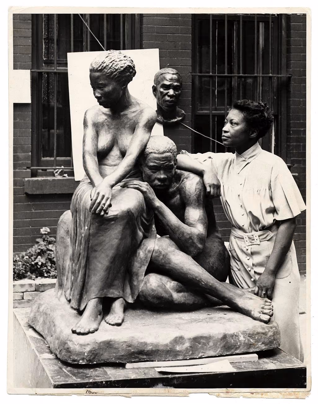 Augusta Savage stands beside her large plaster sculpture Realization.