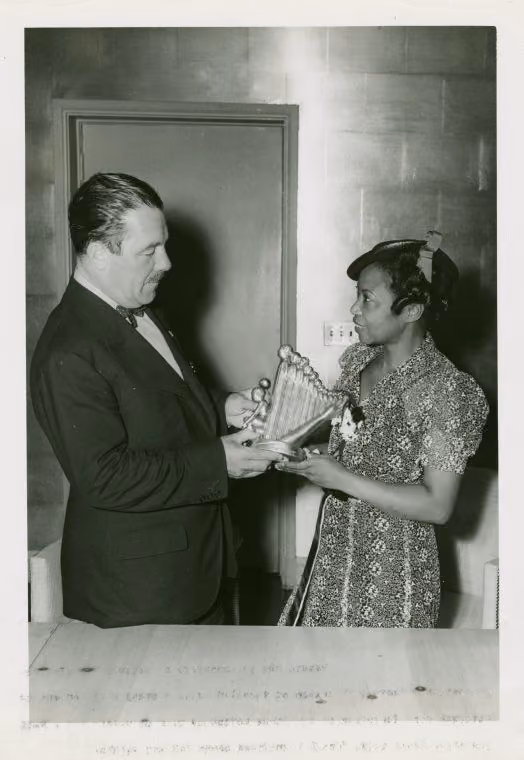 Augusta Savage hands a small model of The Harp to Grover Whalen, the World's Fair president.