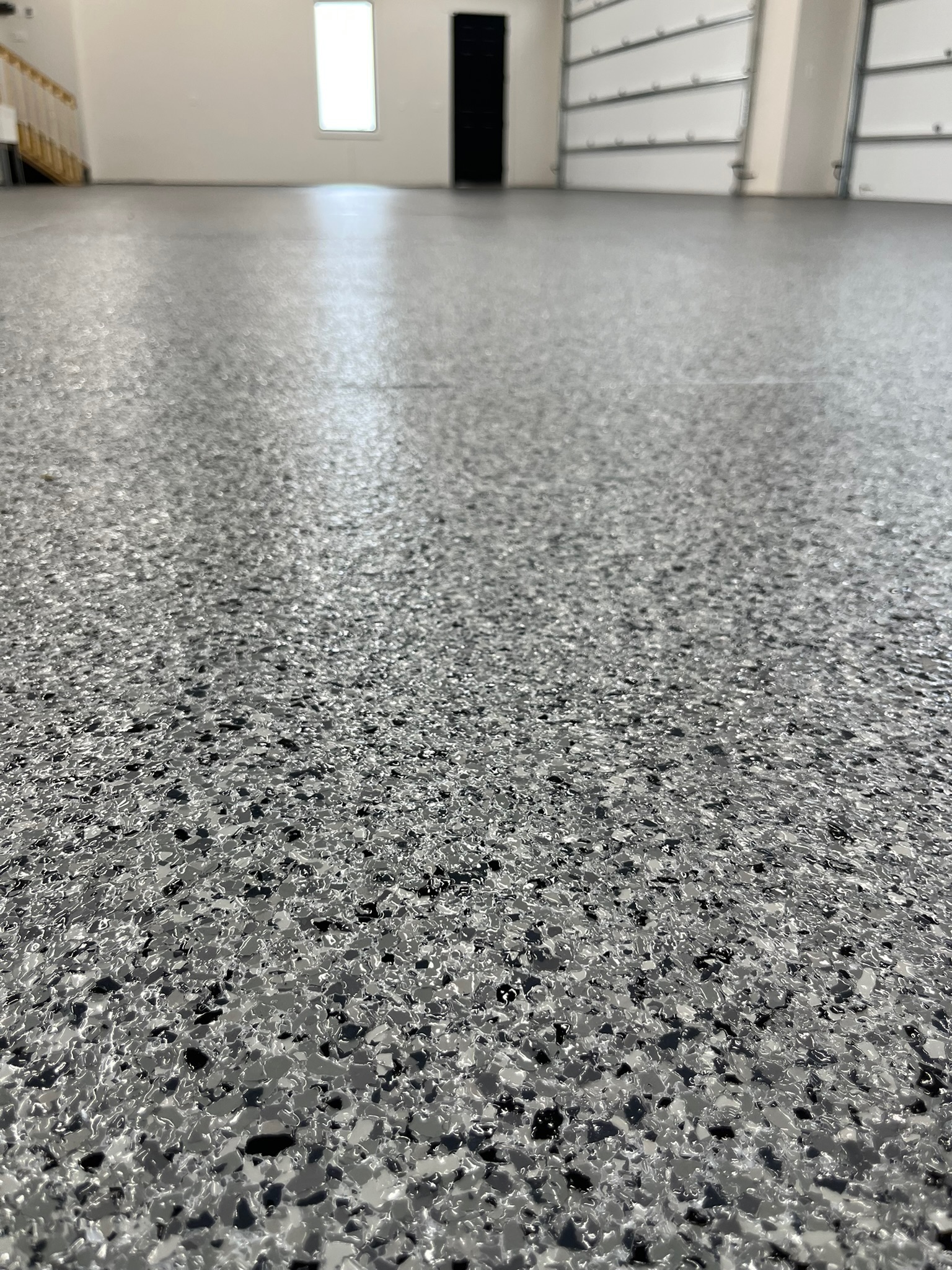 Light brown flake epoxy floor installed in a residential garage in Bismrack ND