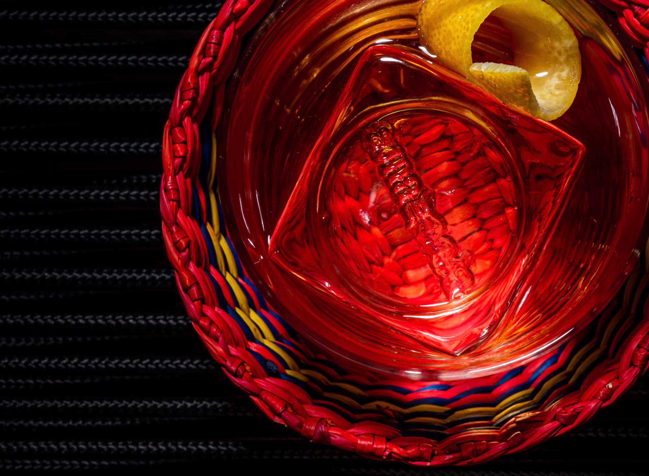 A cocktail adorned with an ice cube that has the amazonia logo imprinted on it