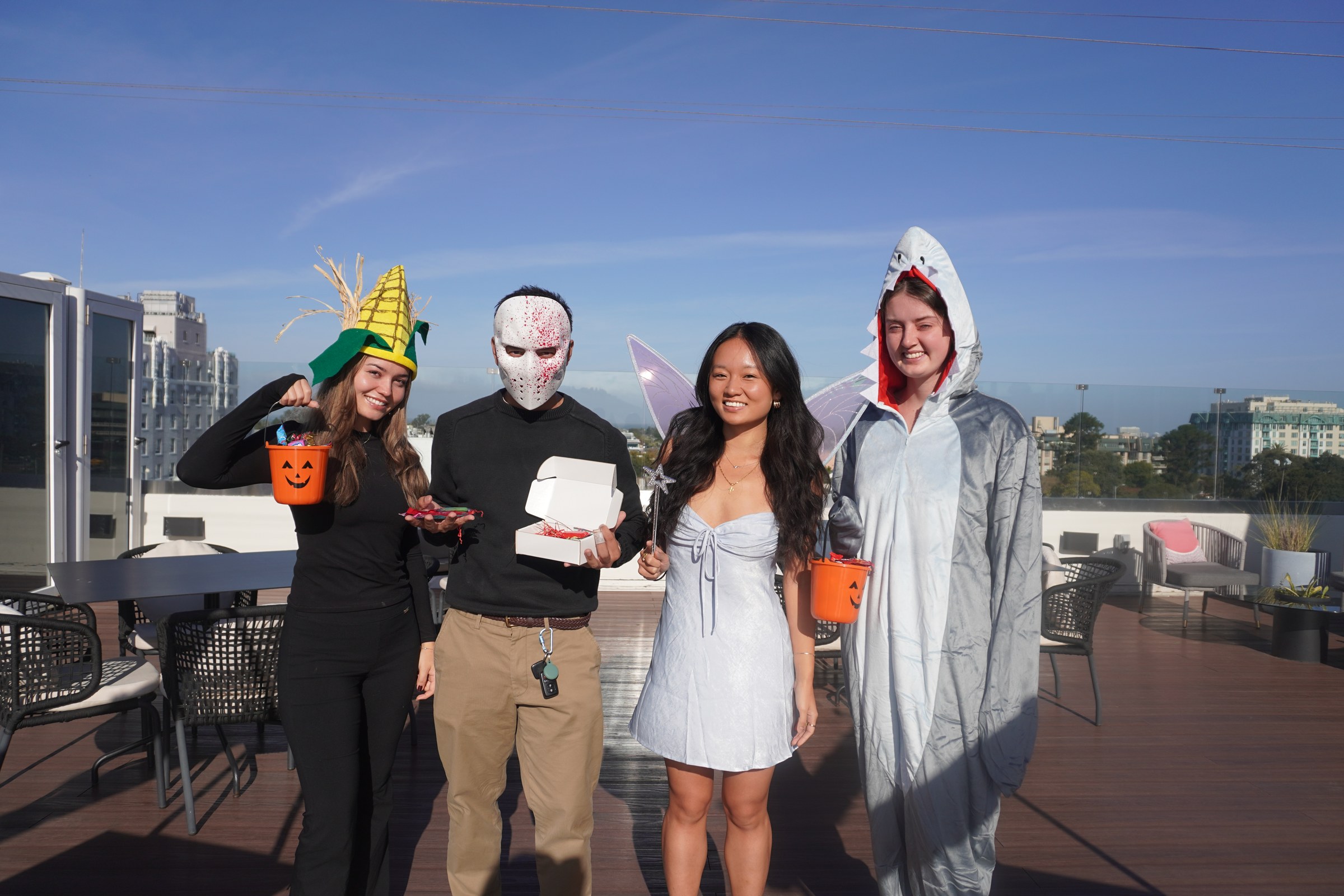 Four Teiko teammates in Halloween costumes on a sunny rooftop patio