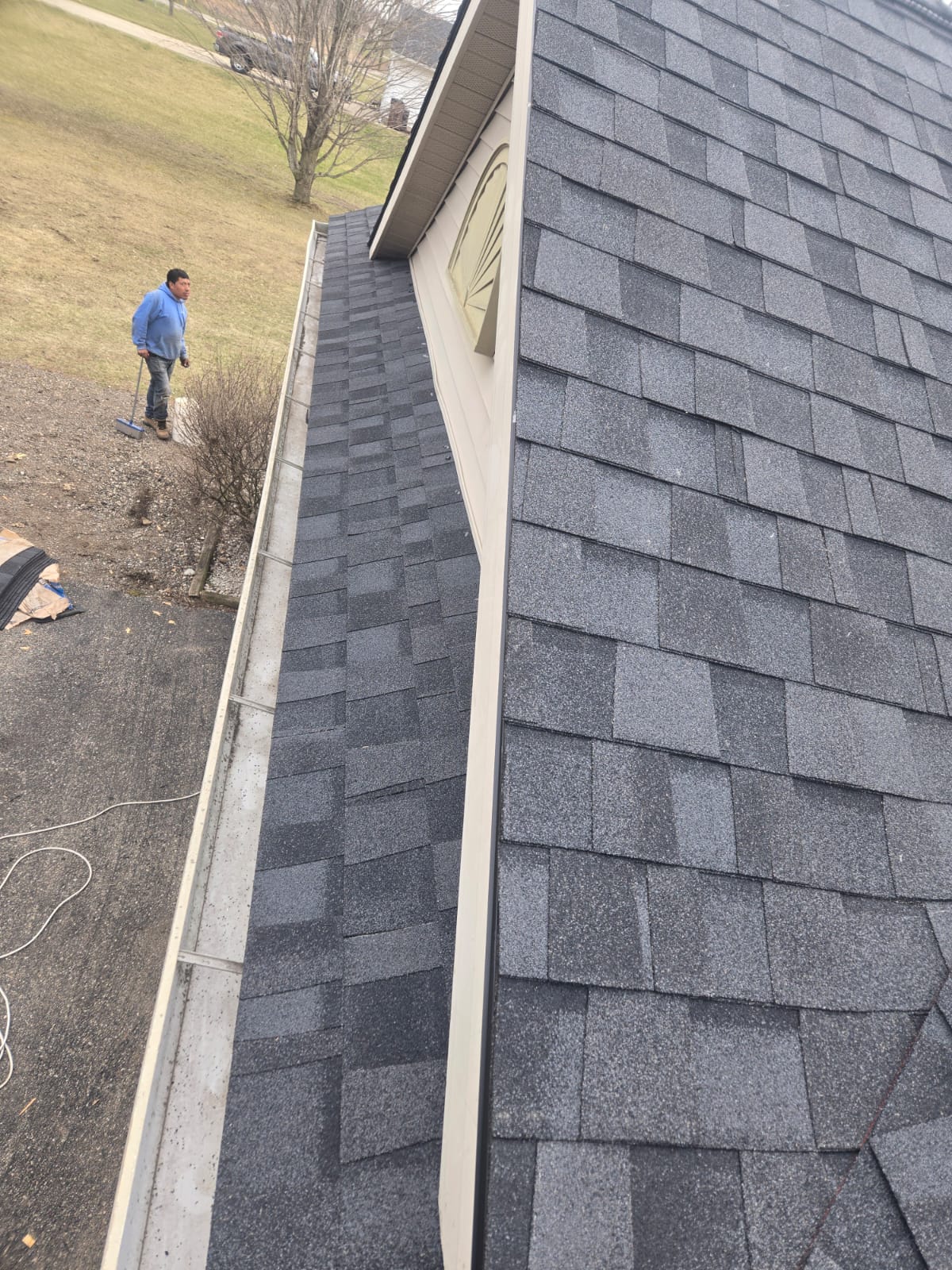 Gray asphalt shingle roof beside a gutter edge