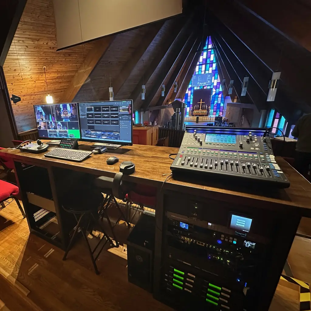 Inside a church, looking down from a sound engineer station with AV equipment, monitoring frequencies and channels to avoid RF intereference.