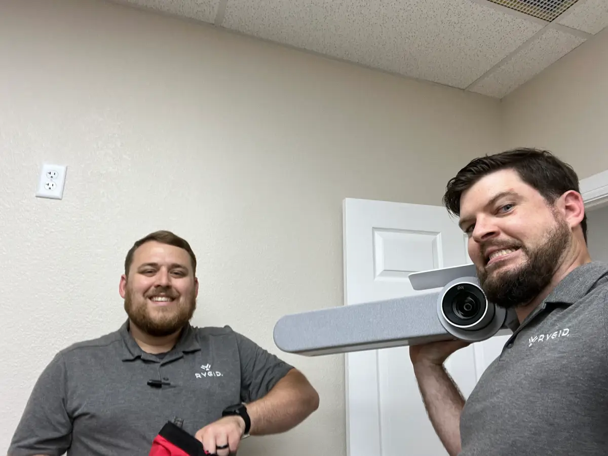 Two RYGID AV technicians installing commercial video conferencing camera in conference room